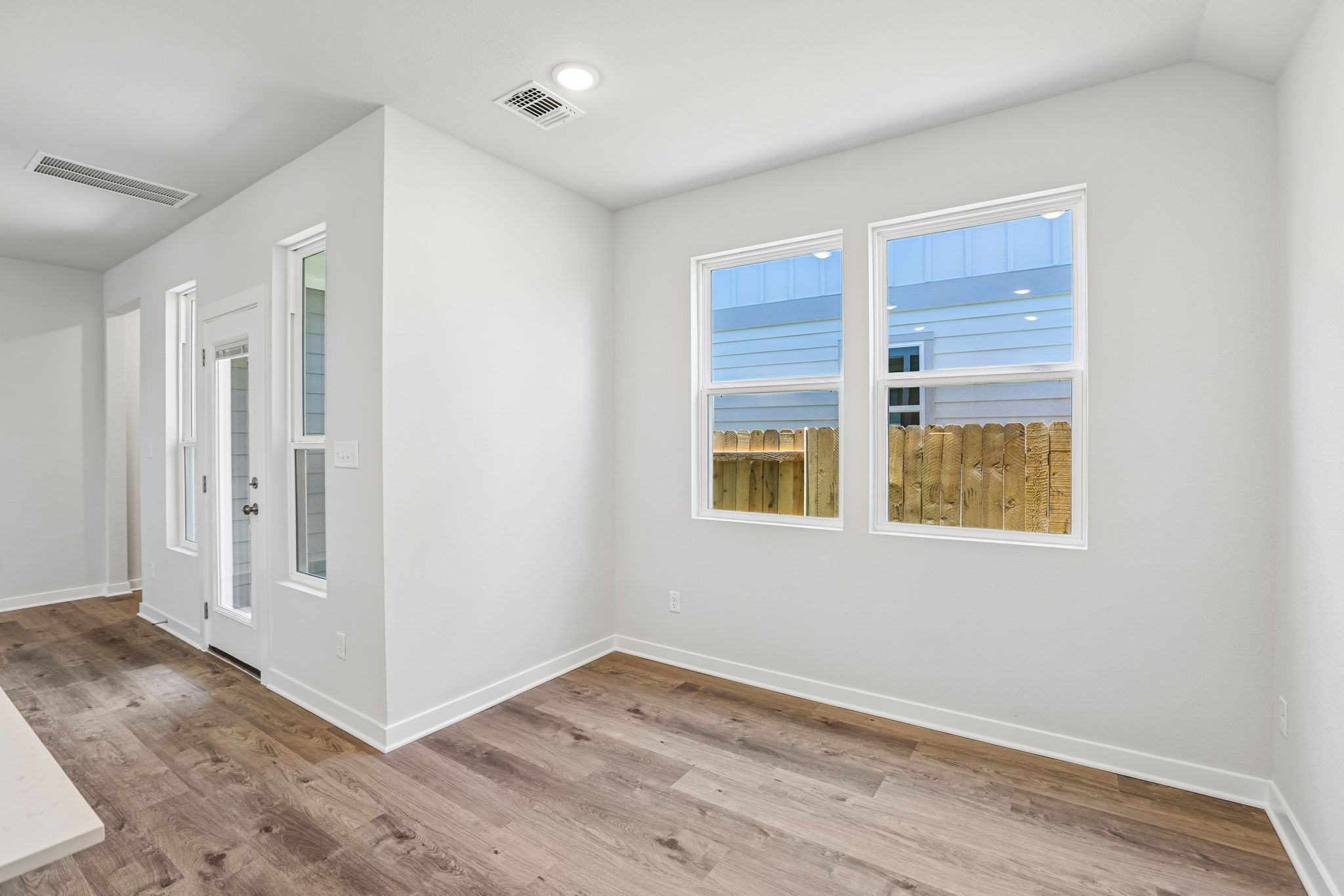 A room with a wood floor and windows.
