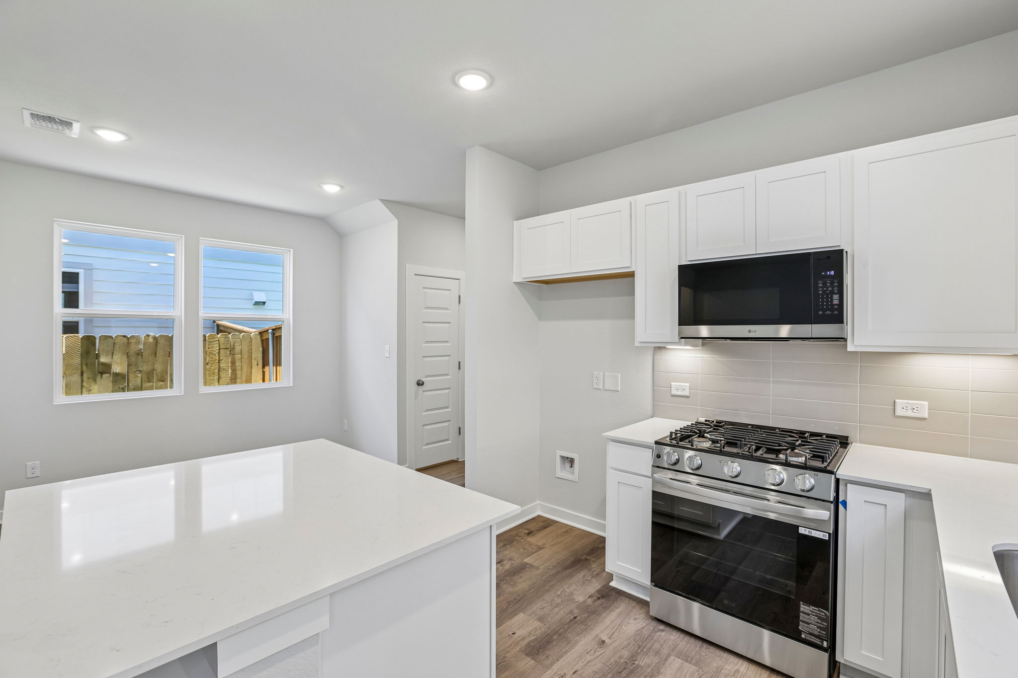 A kitchen with white cabinets.