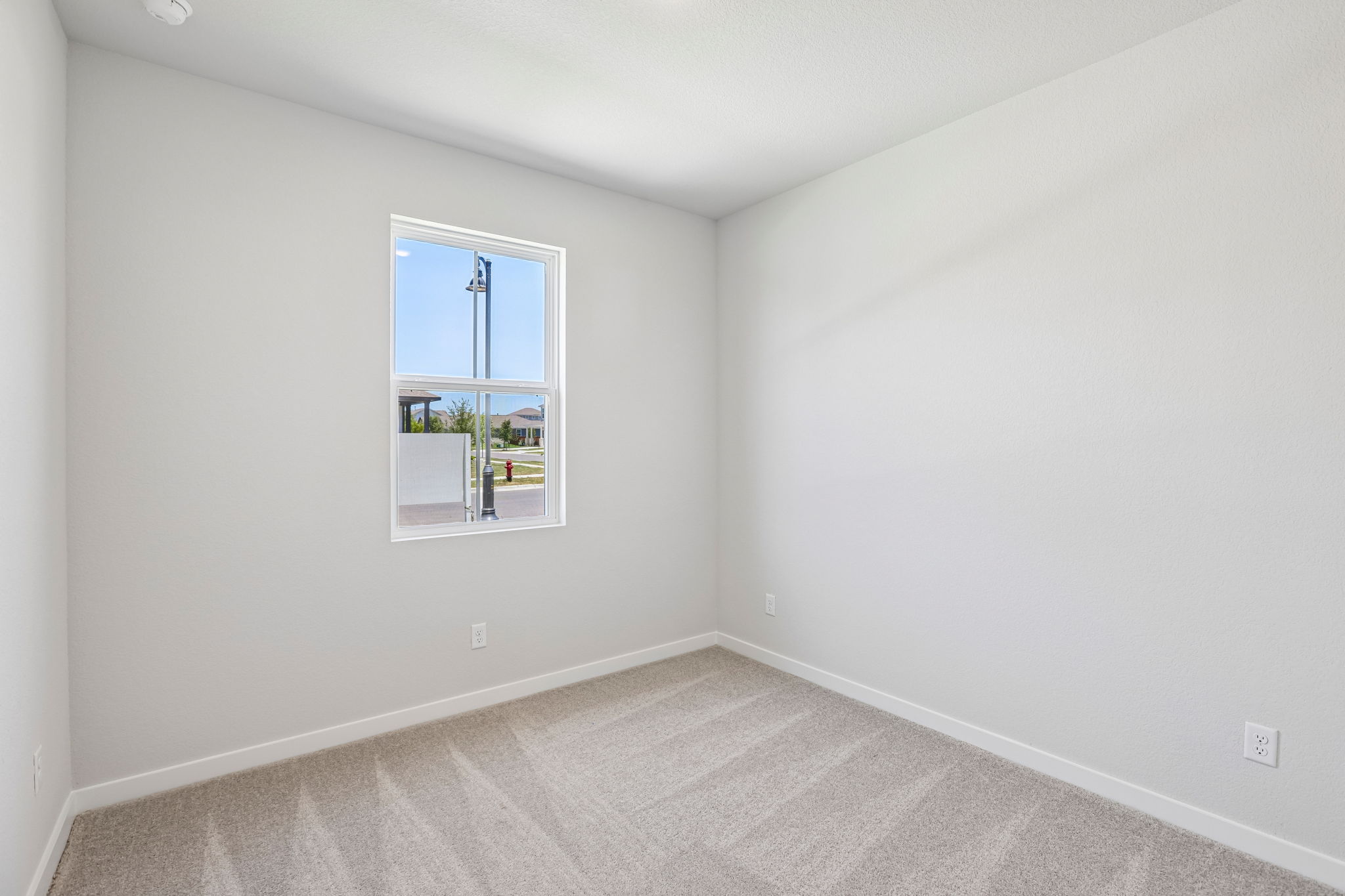 A room with a window and a rug.