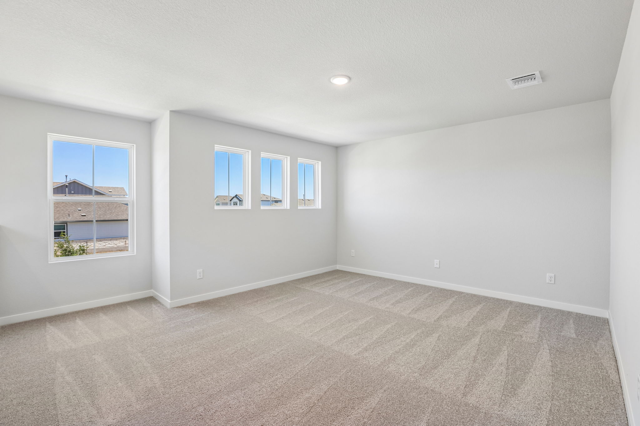A room with a carpet and windows.