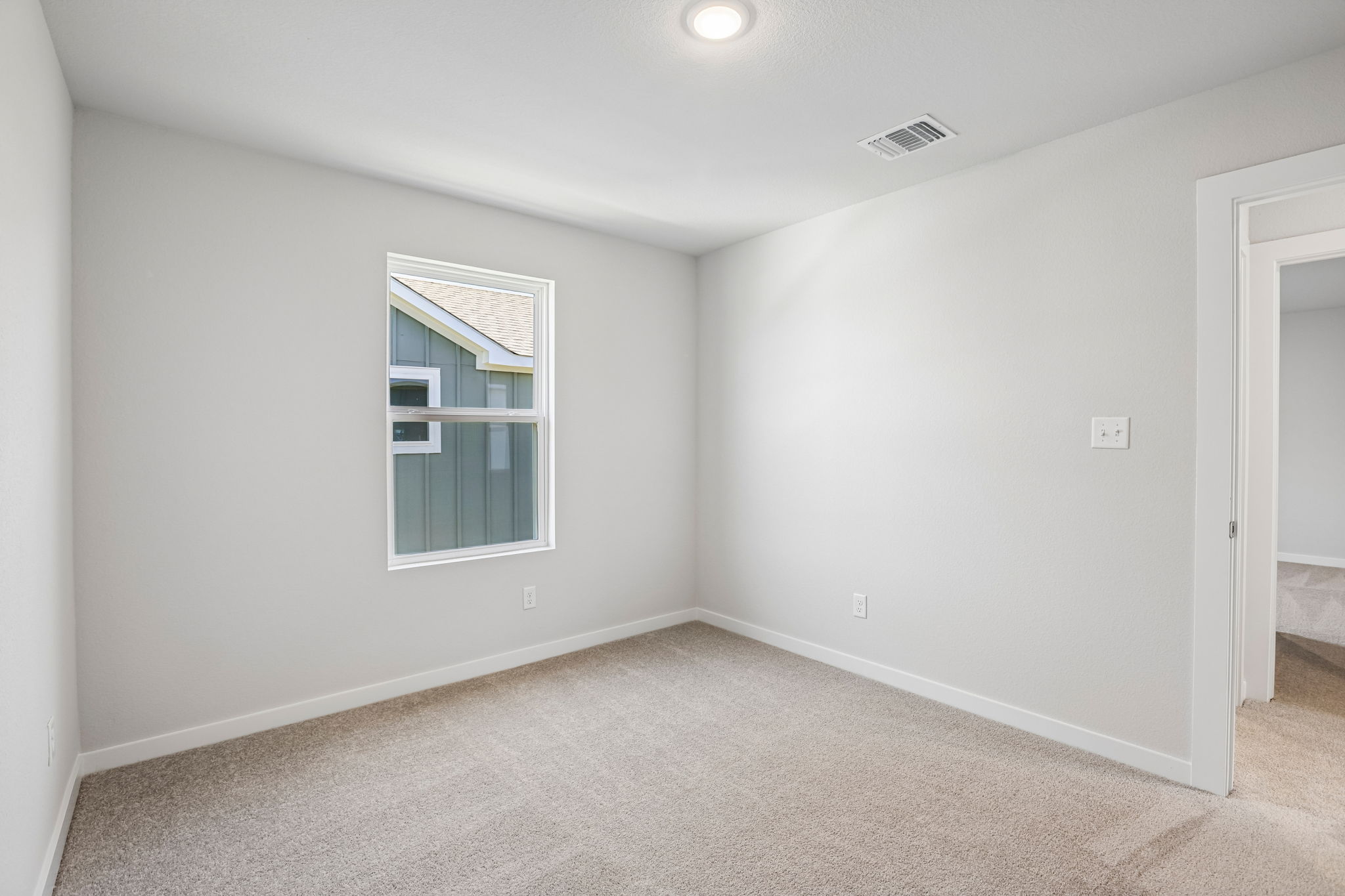 A room with a window and carpet.