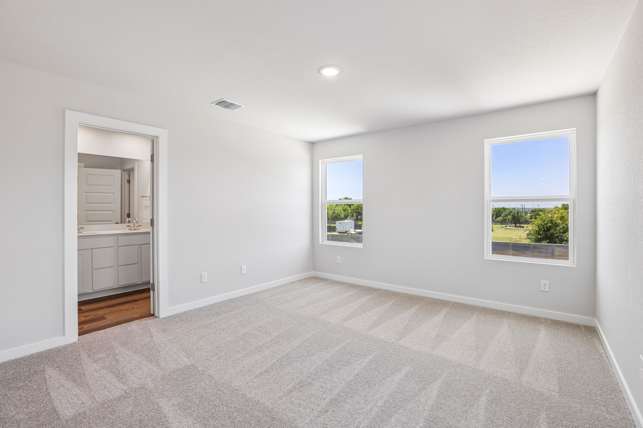 A room with a white wall and windows.