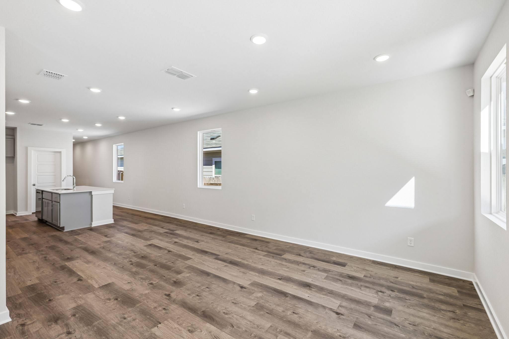 A room with a wood floor and white walls.