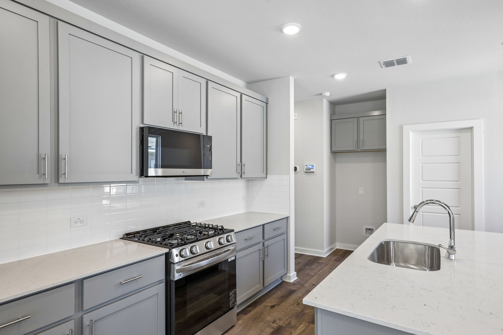 A kitchen with white cabinets.