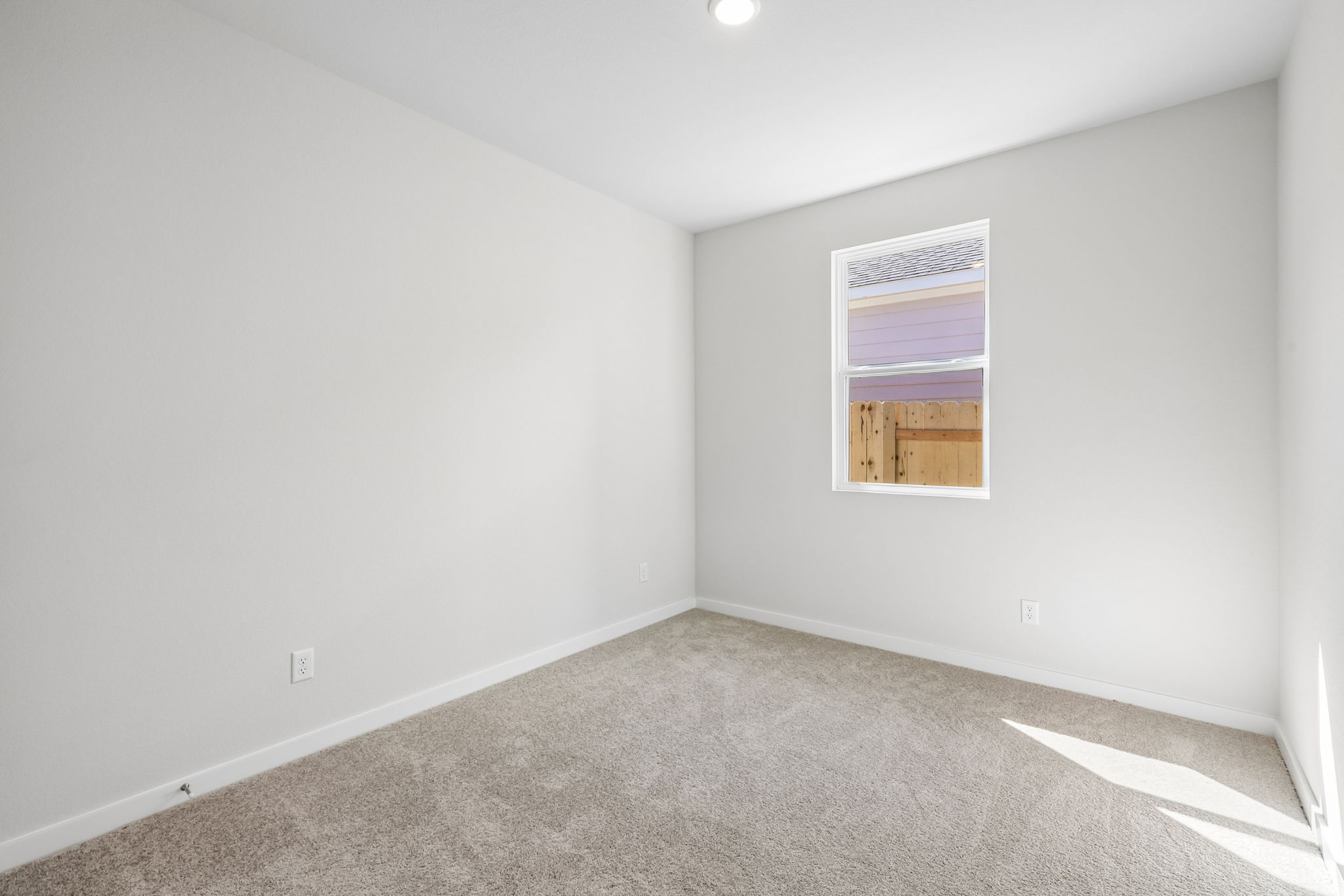 A room with a window and carpet.