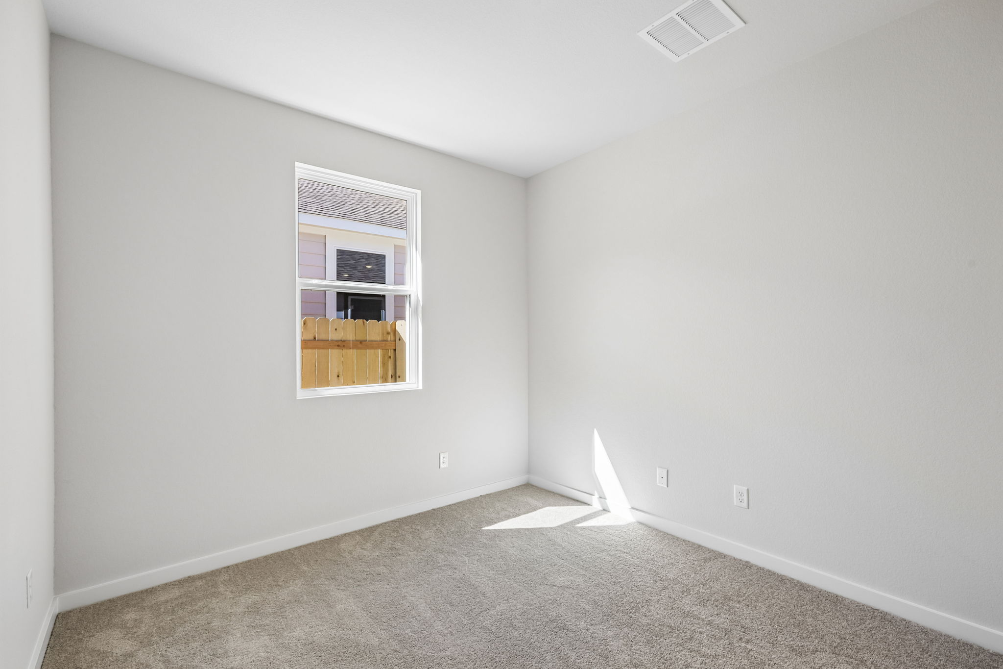 A room with a window and a carpet.