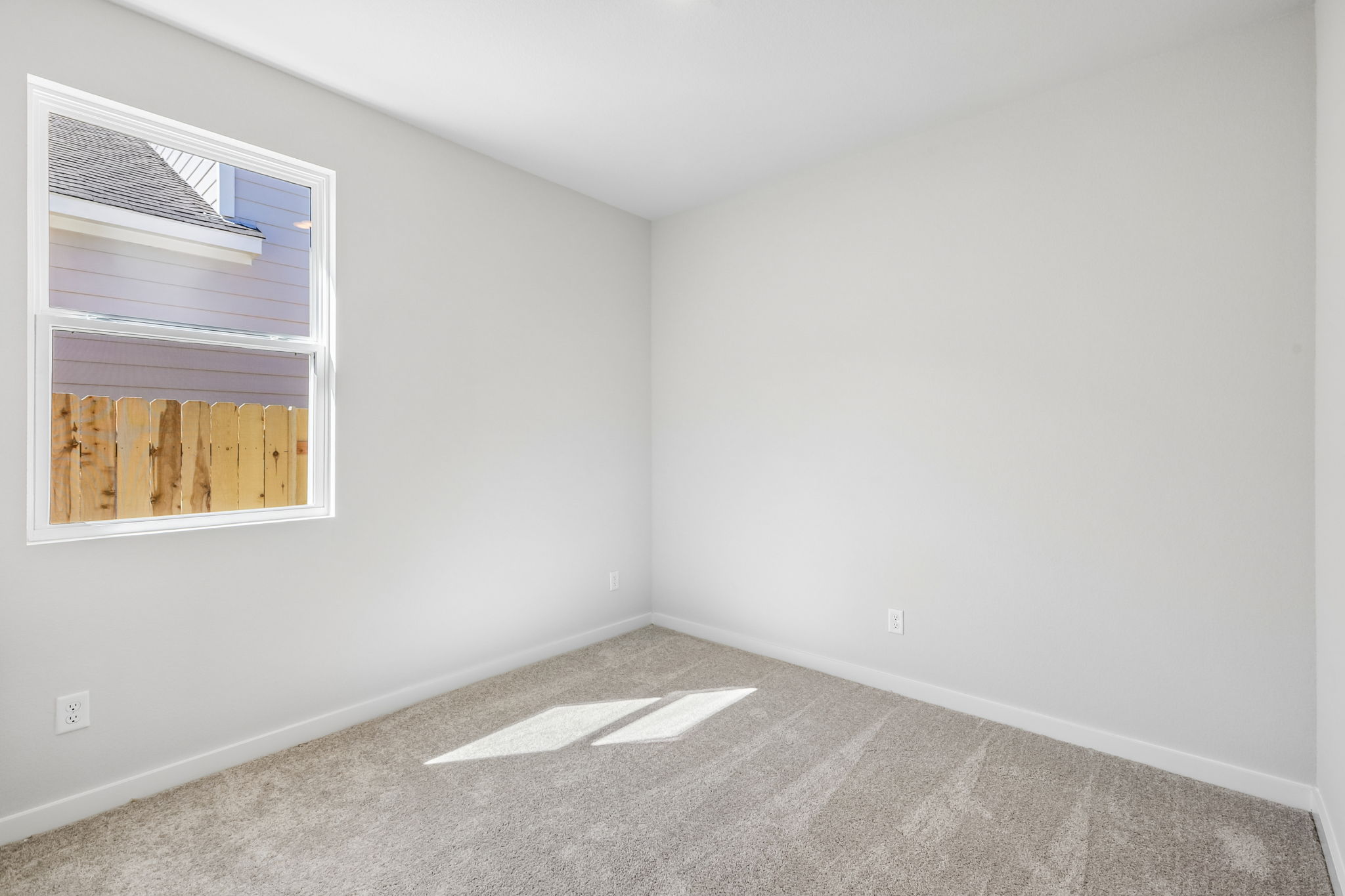 A room with a window and a rug.