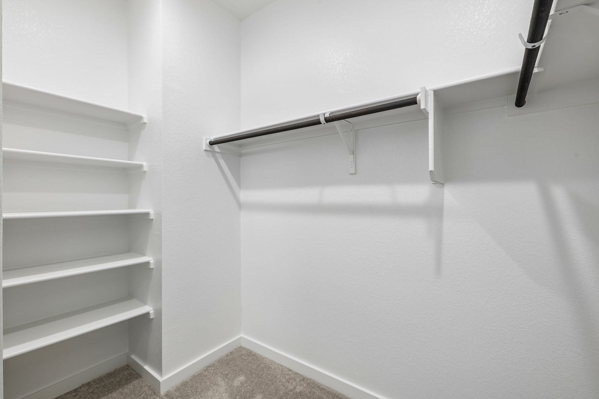 A white shelf with a metal bar.