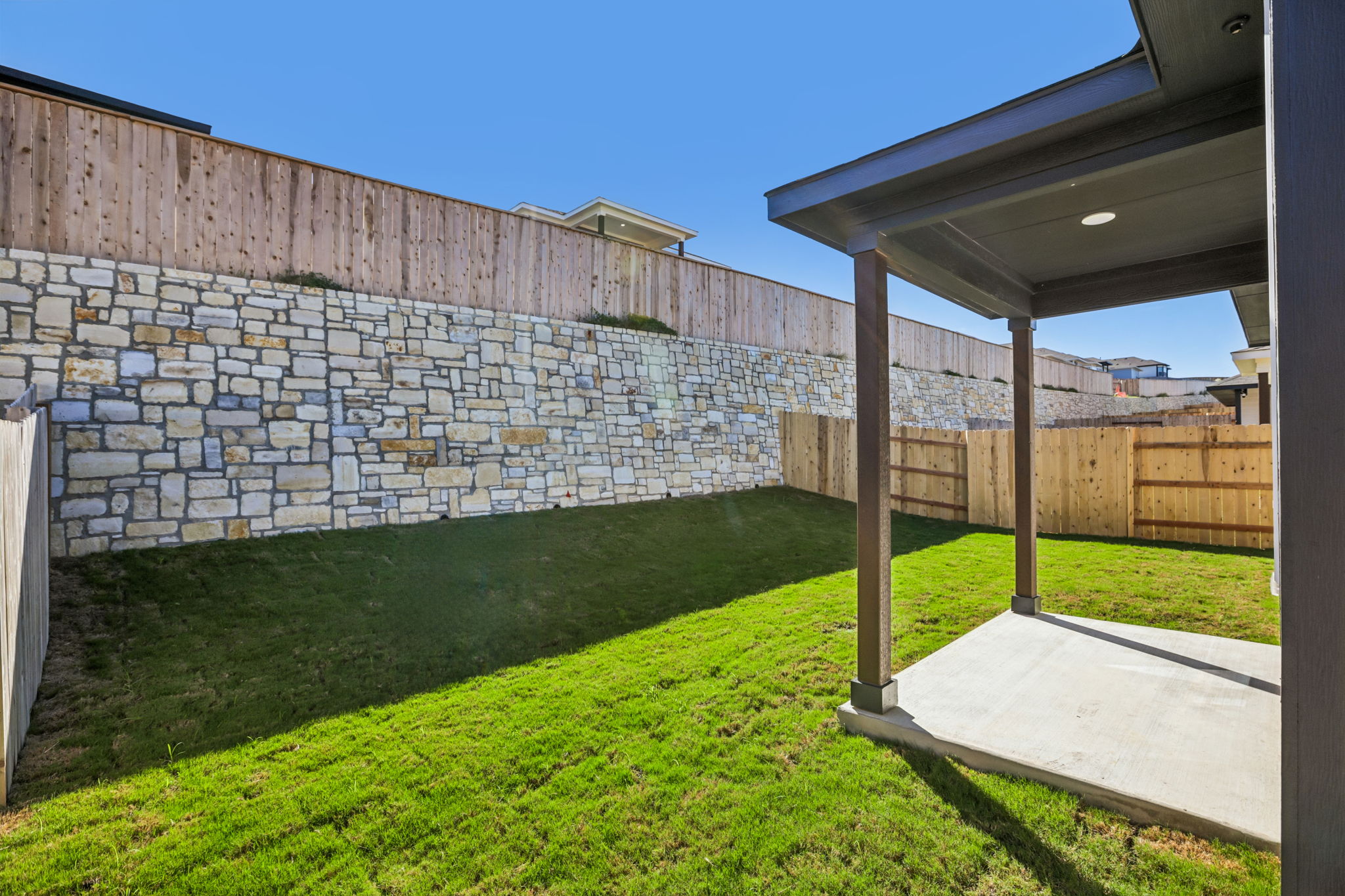 A backyard with a brick wall.