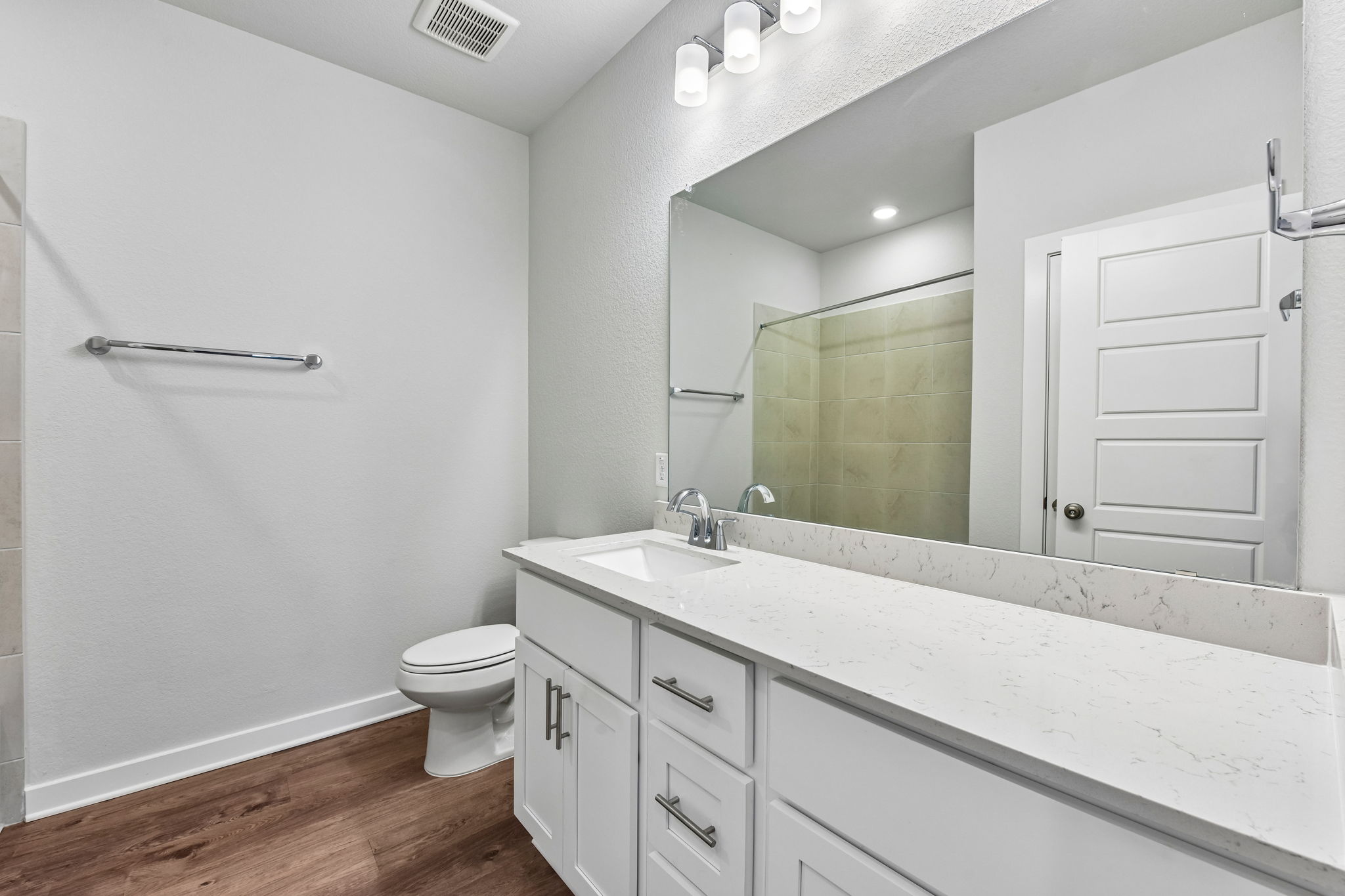 A bathroom with a large mirror.