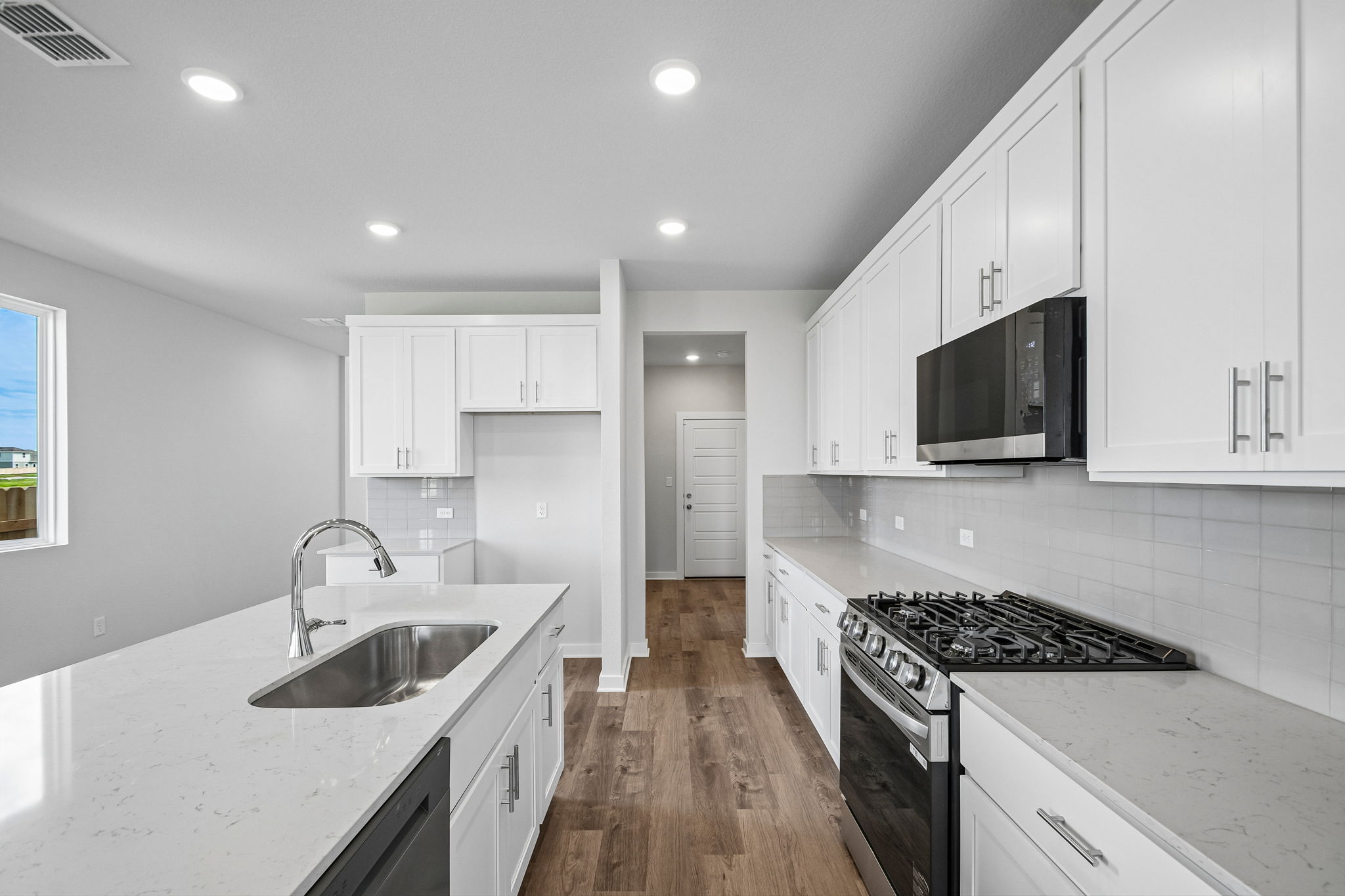 A kitchen with white cabinets.
