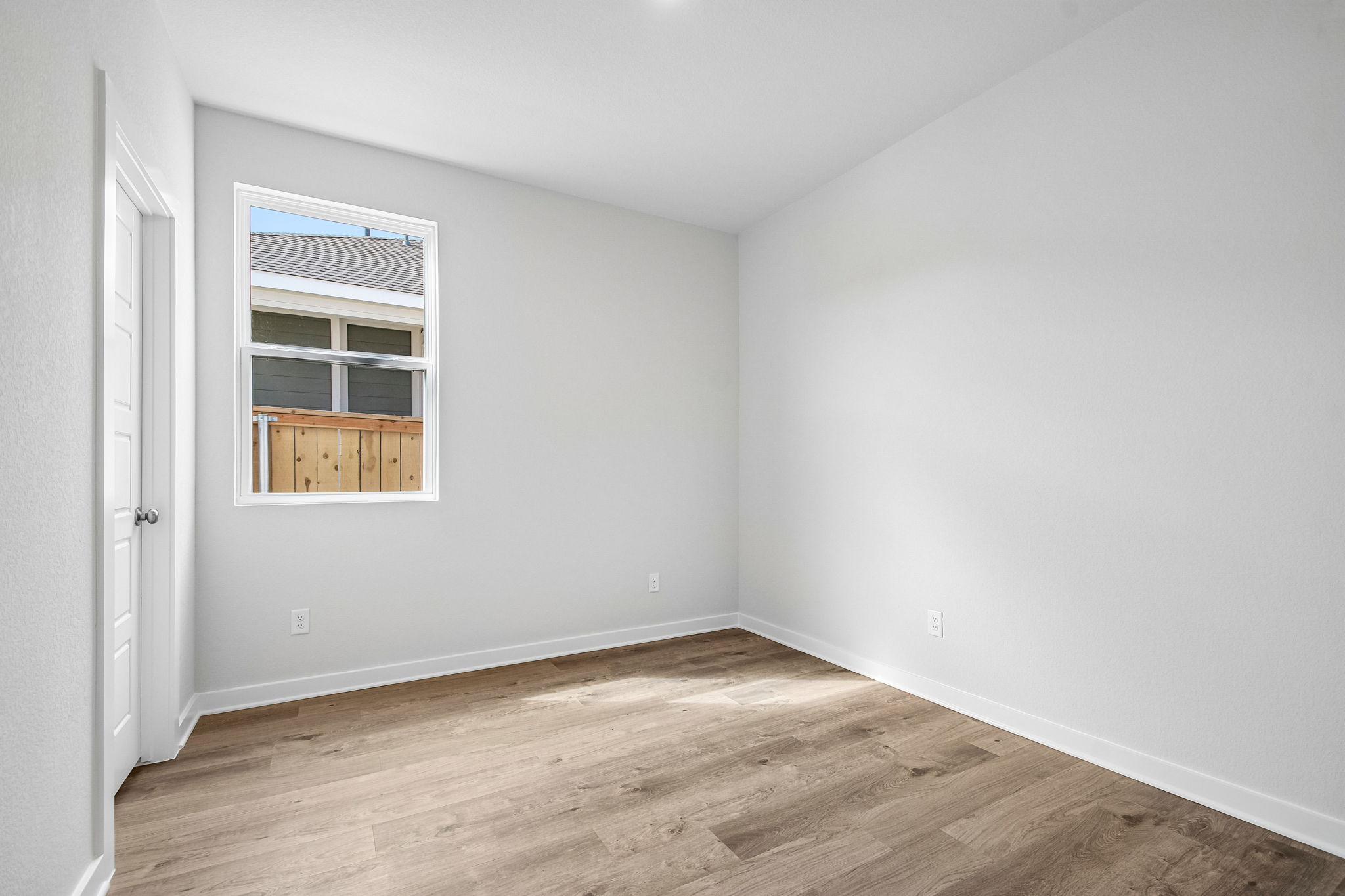 A room with a wood floor and a window.