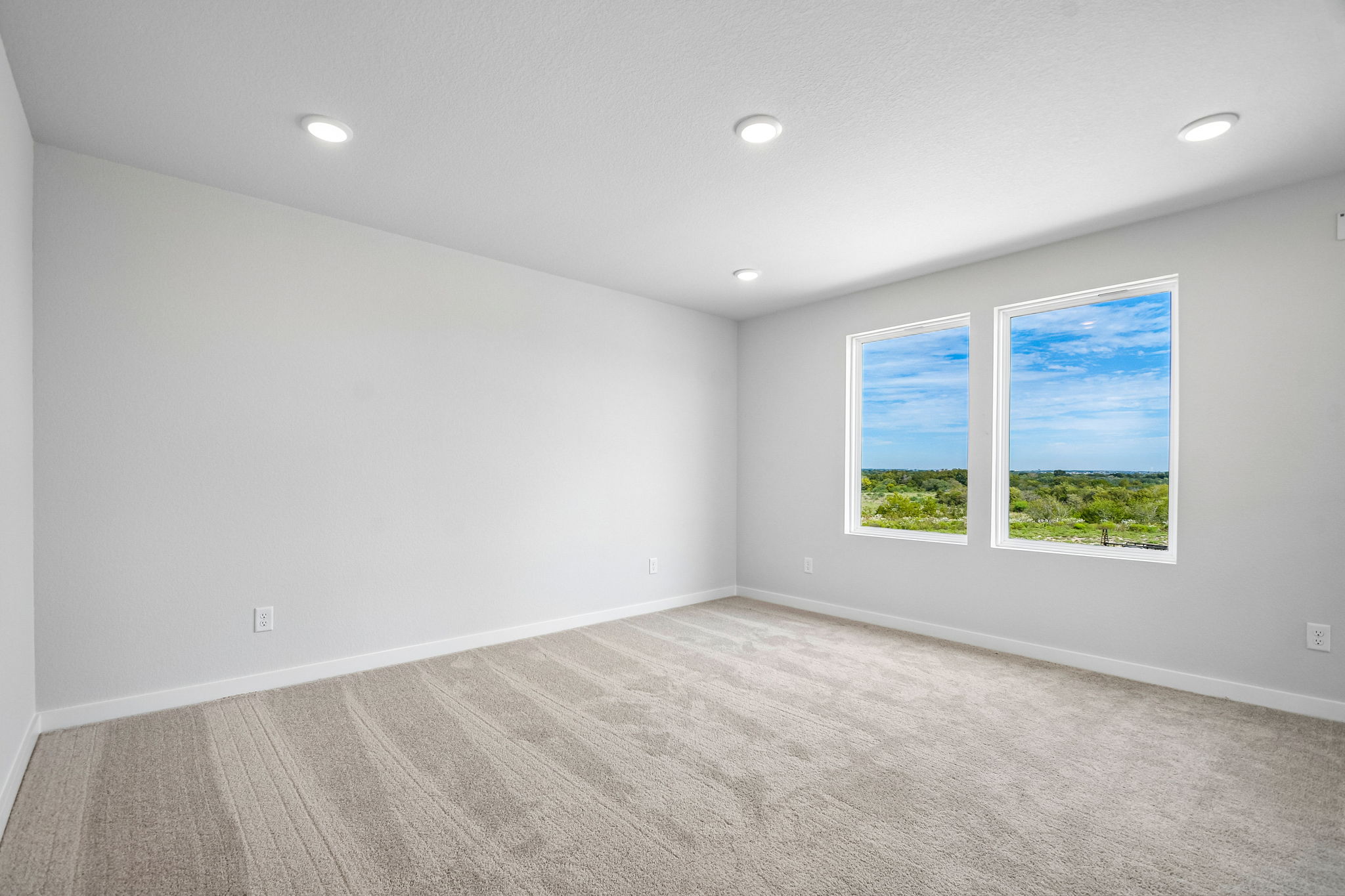 A room with a window and a wood floor.