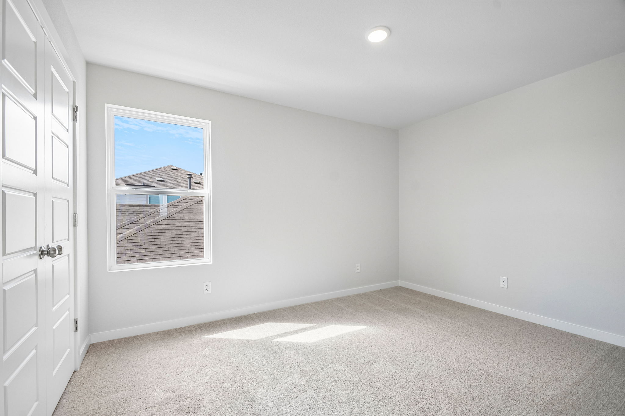 A room with white walls and a painting on the wall.