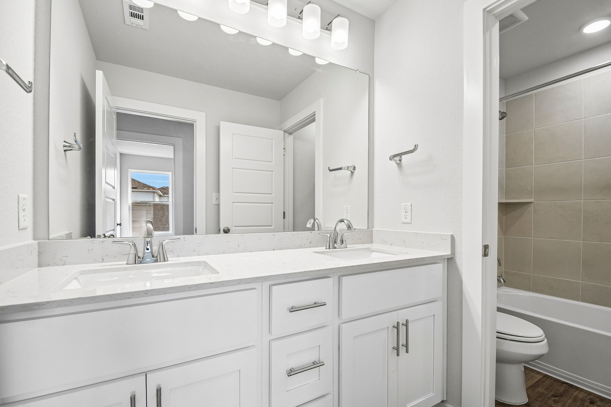 A bathroom with a large mirror.