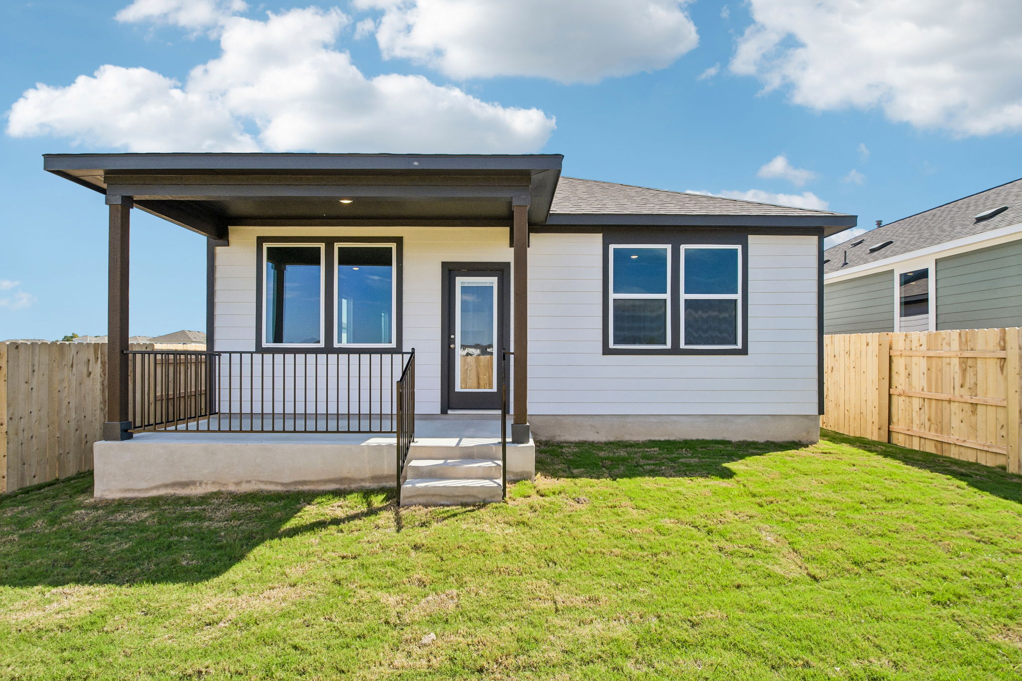A house with a fence and grass.