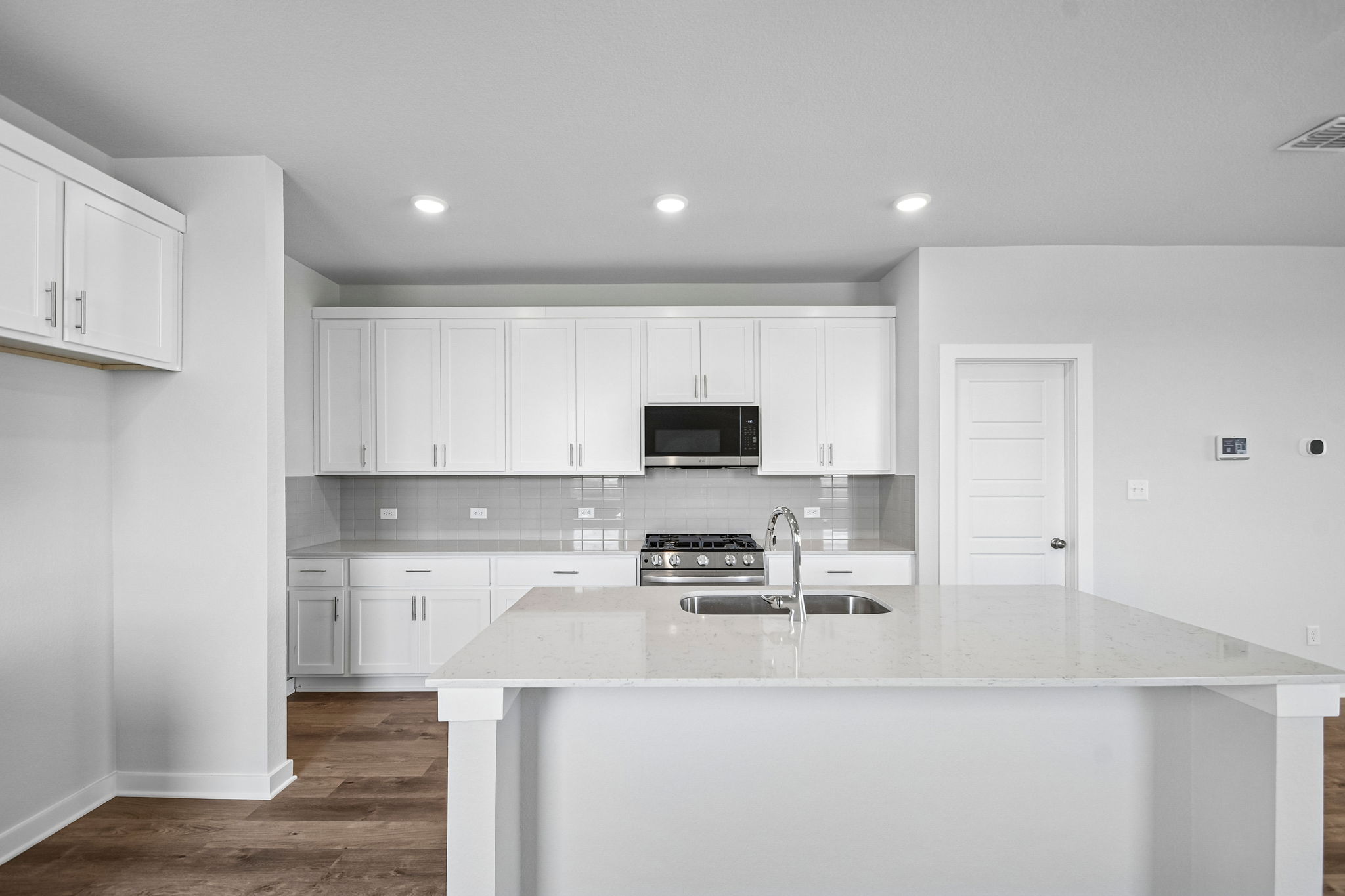 A kitchen with white cabinets.