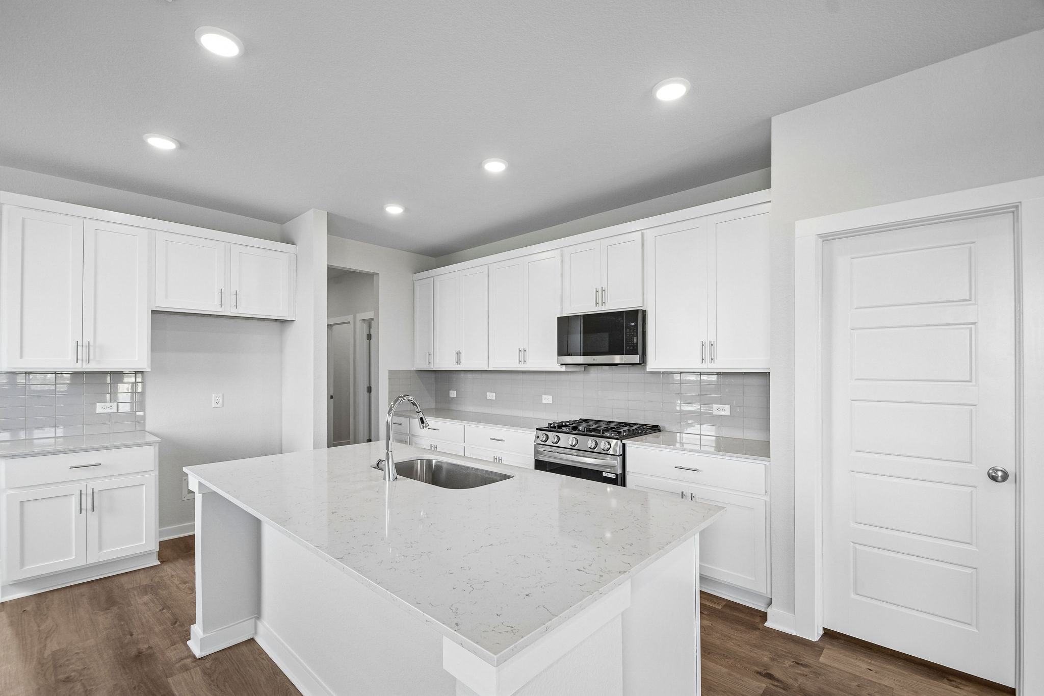 A kitchen with white cabinets.