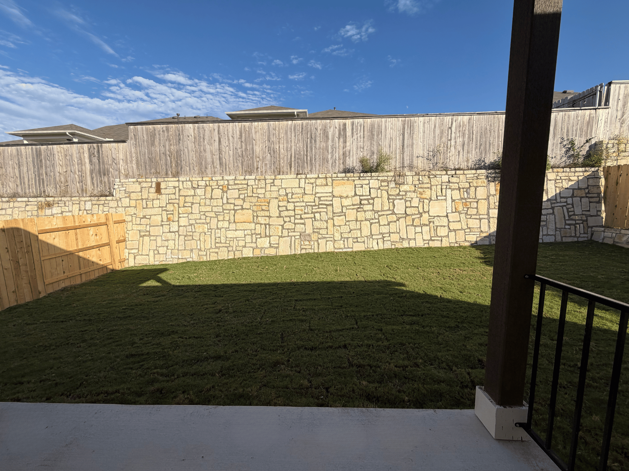 A stone wall with a fence.