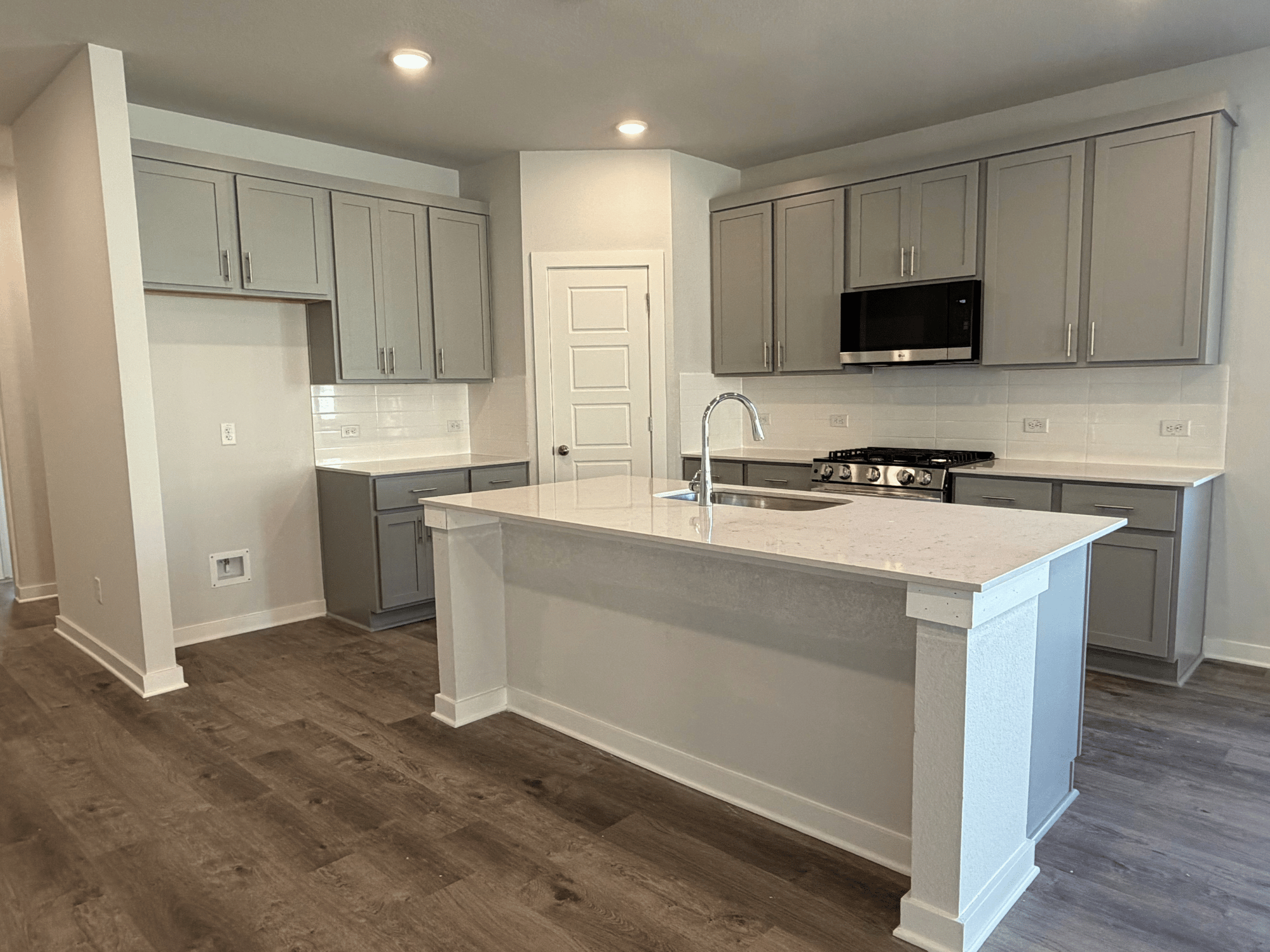 A kitchen with white cabinets.