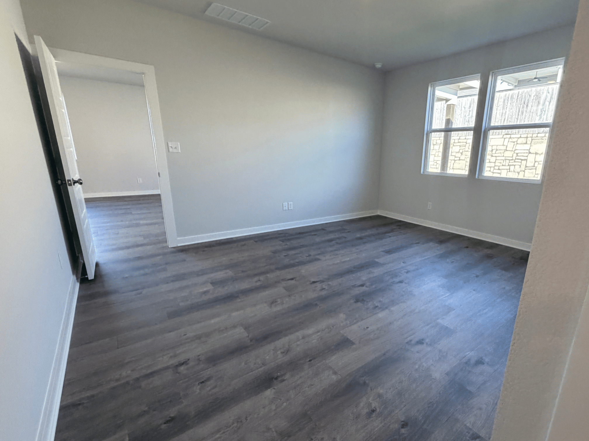 A room with a wood floor and a window.