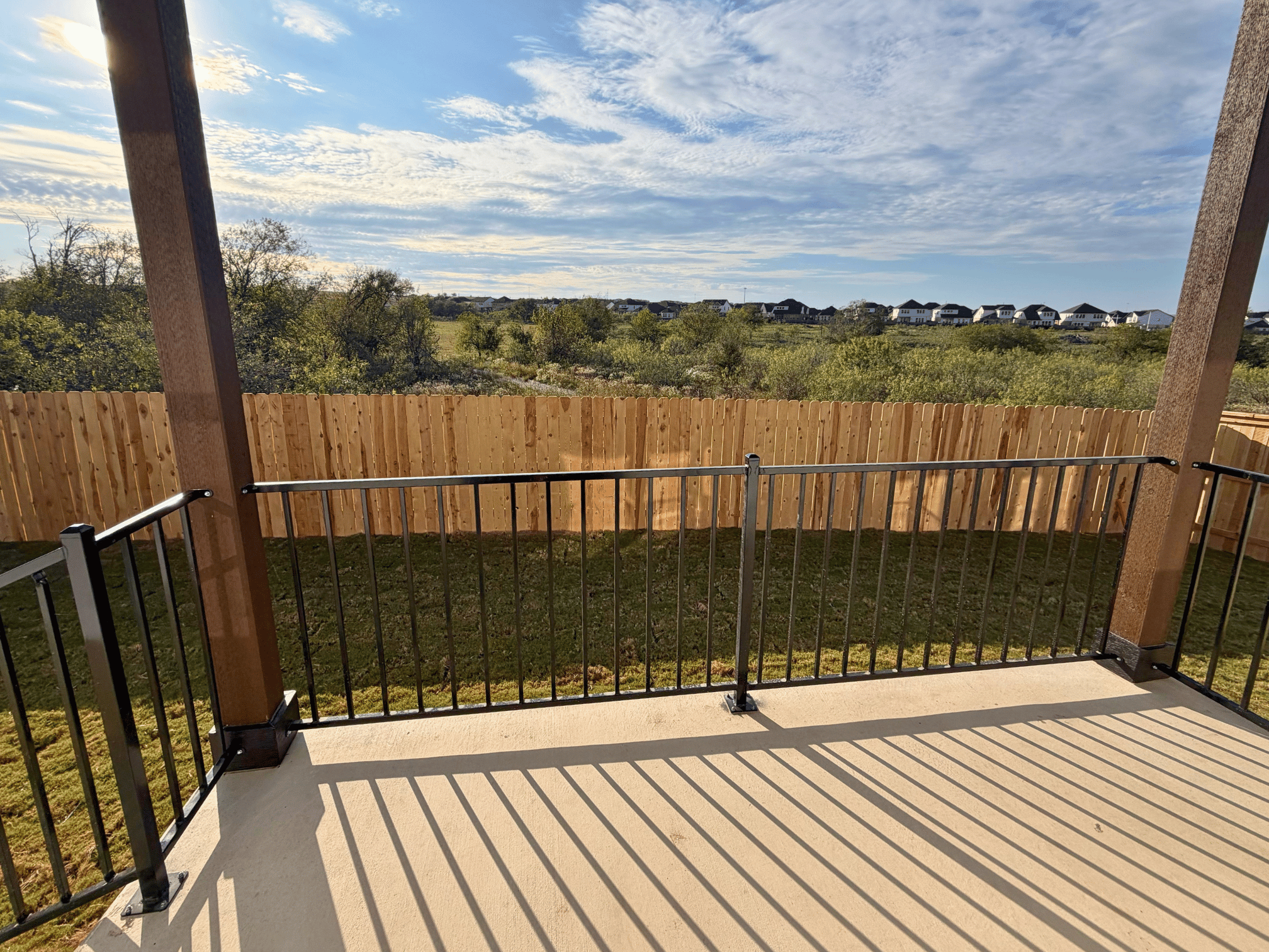 A deck with a railing and trees in the background.