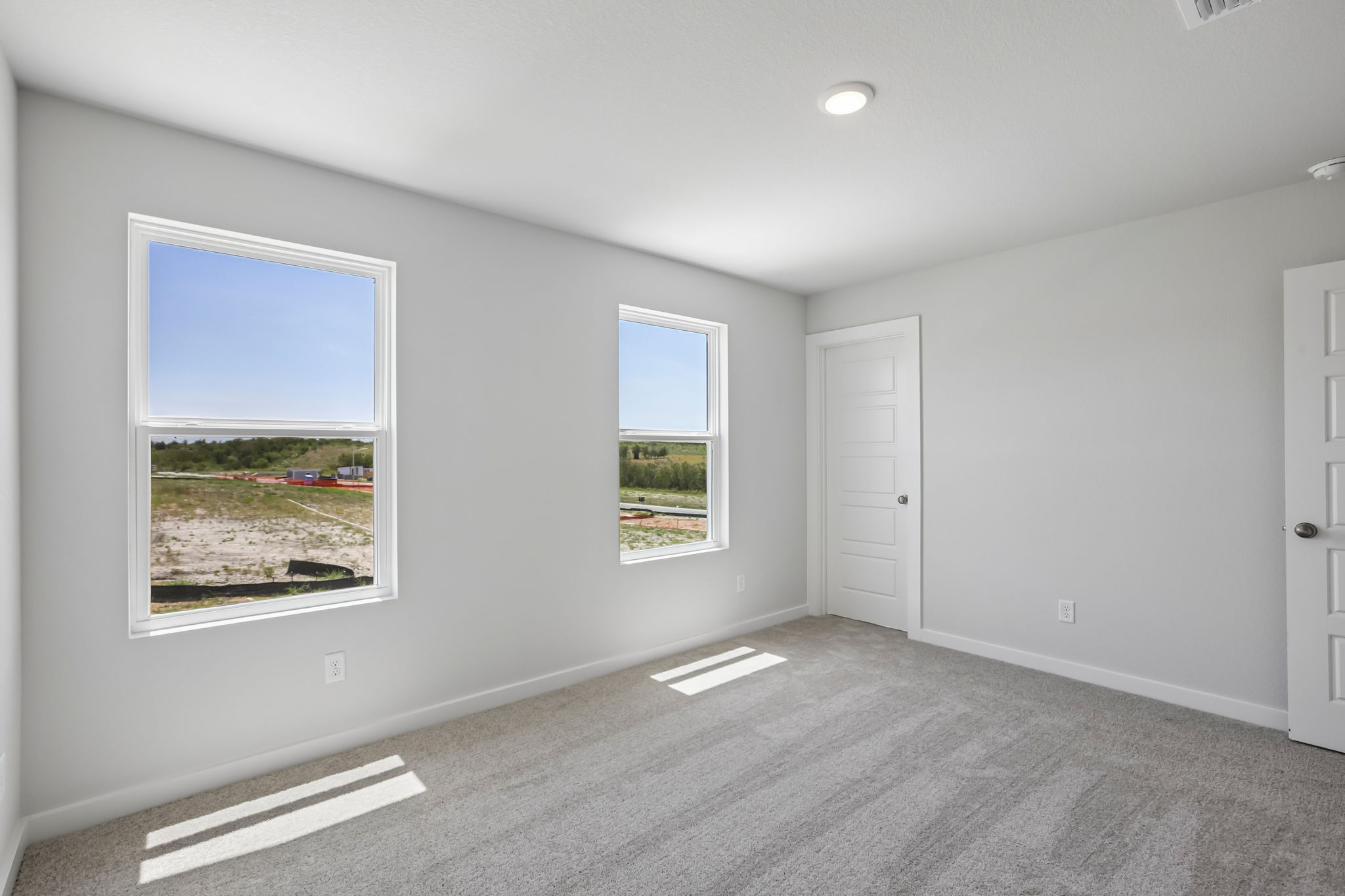 A room with windows and a carpet.