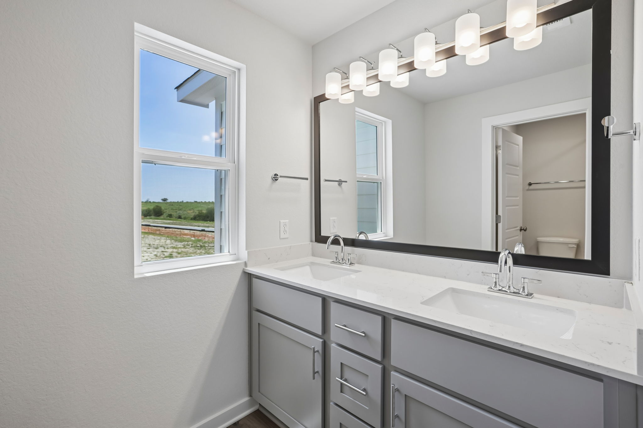 A bathroom with a large mirror.