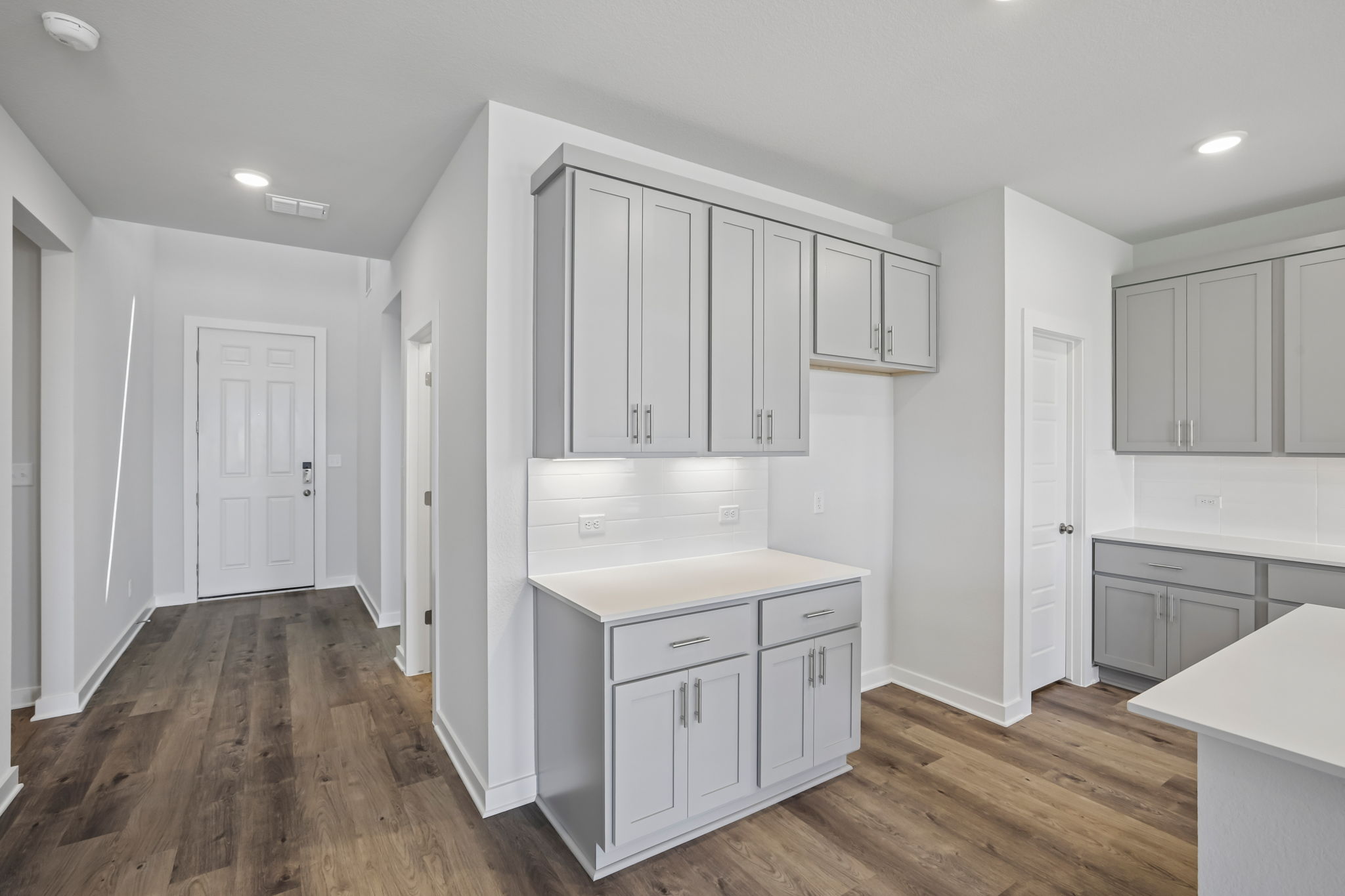 A kitchen with white cabinets.