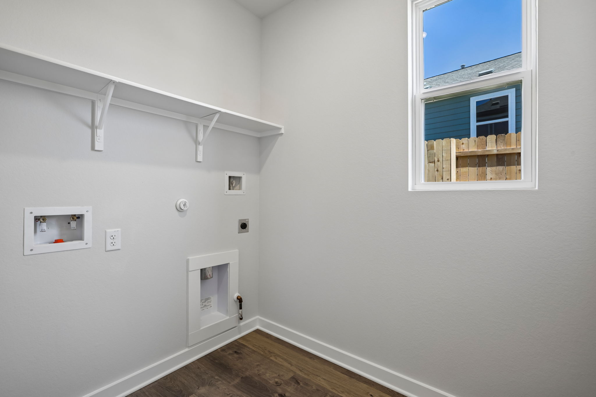 A room with a window and a wood floor.