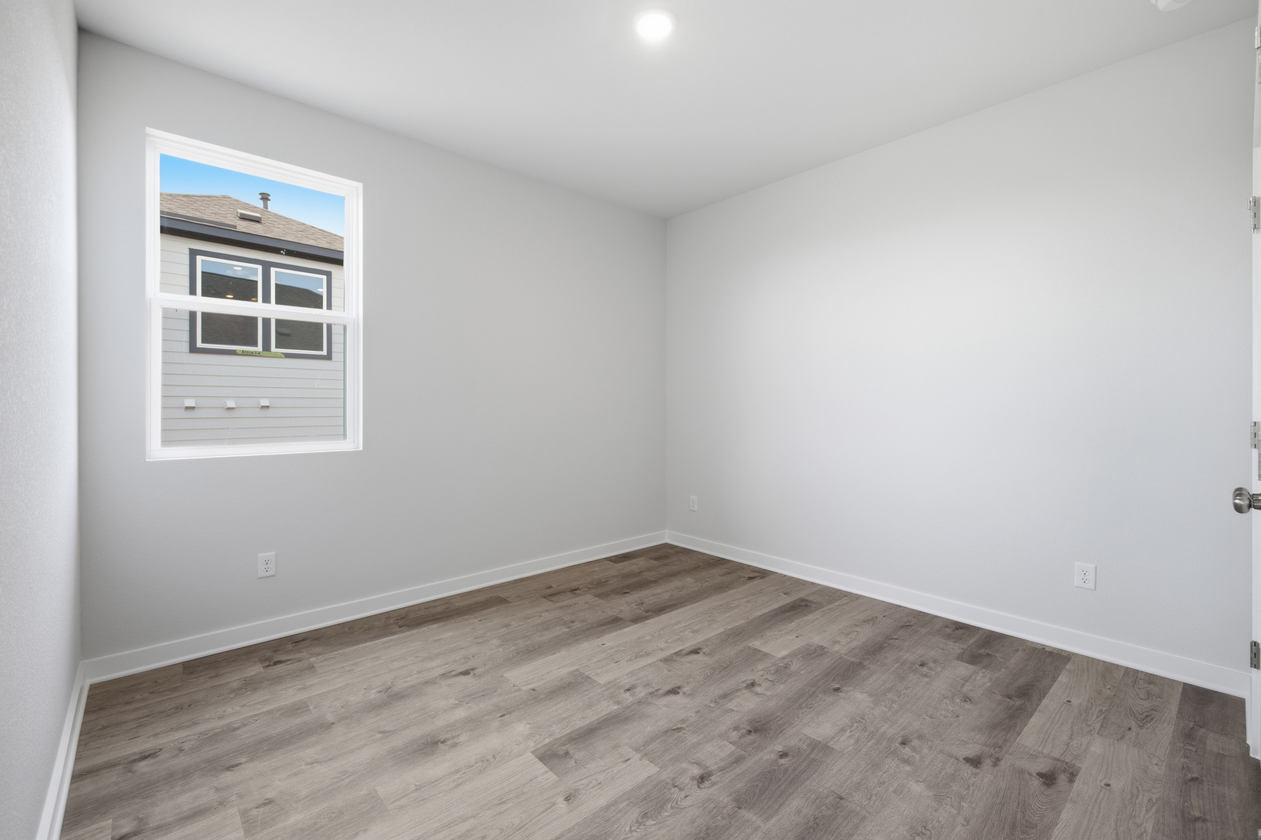 A room with a wood floor and a window.
