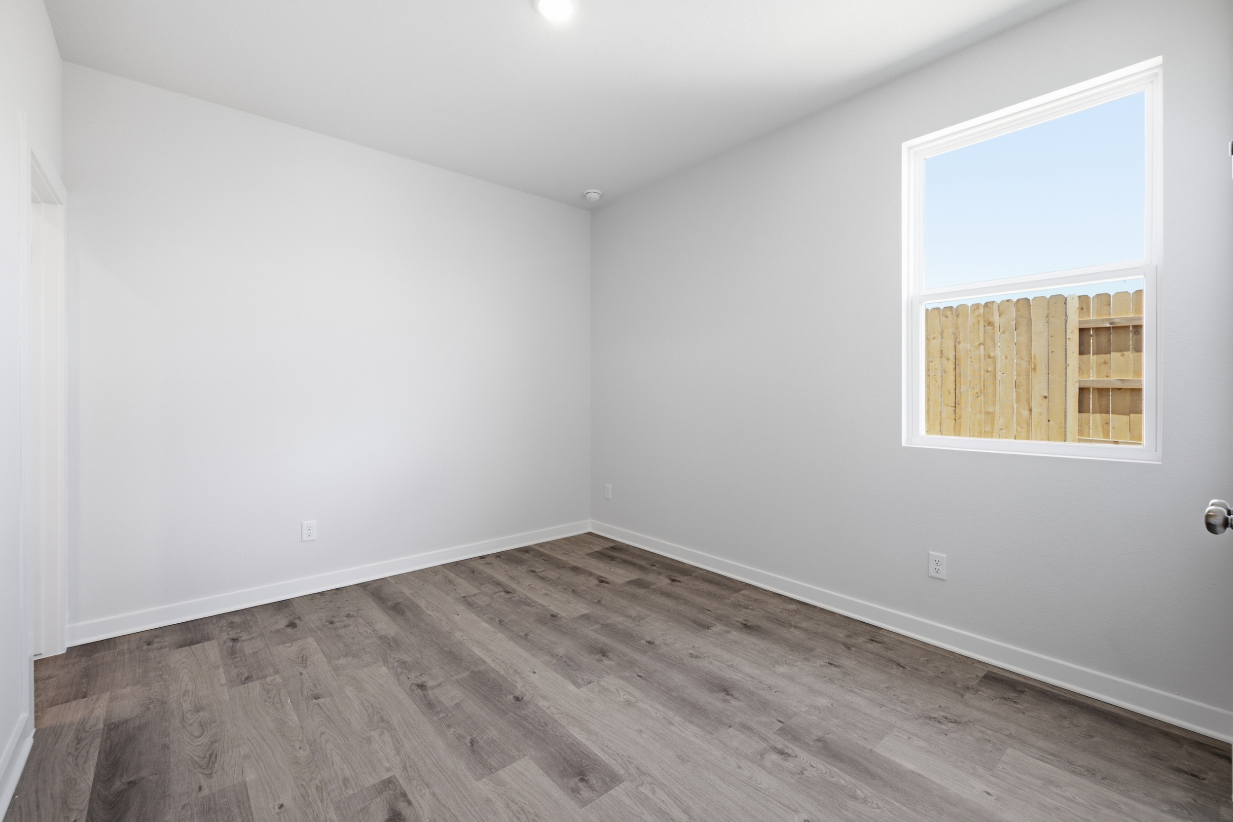 A room with a wood floor and a window.