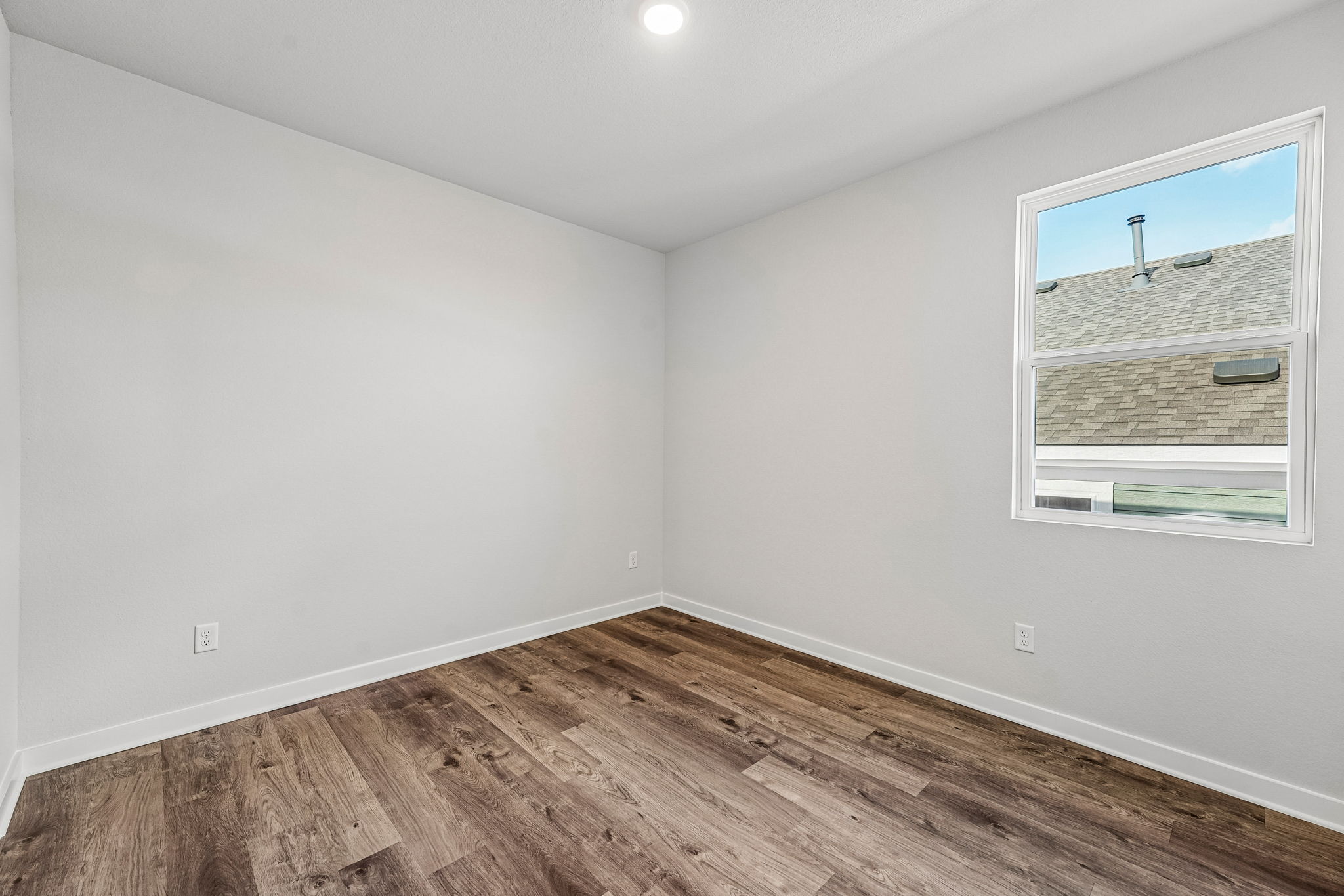 A room with a wood floor and a window.