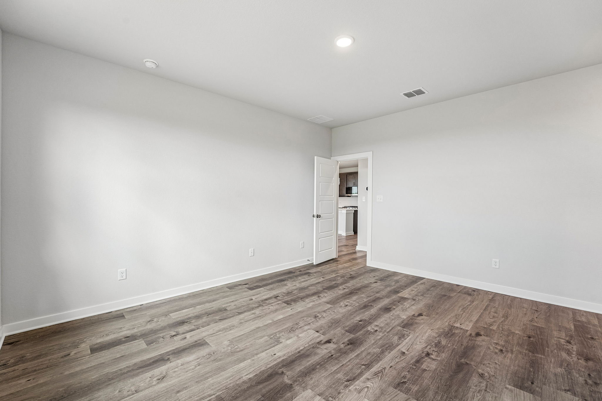A room with a wood floor and white walls.