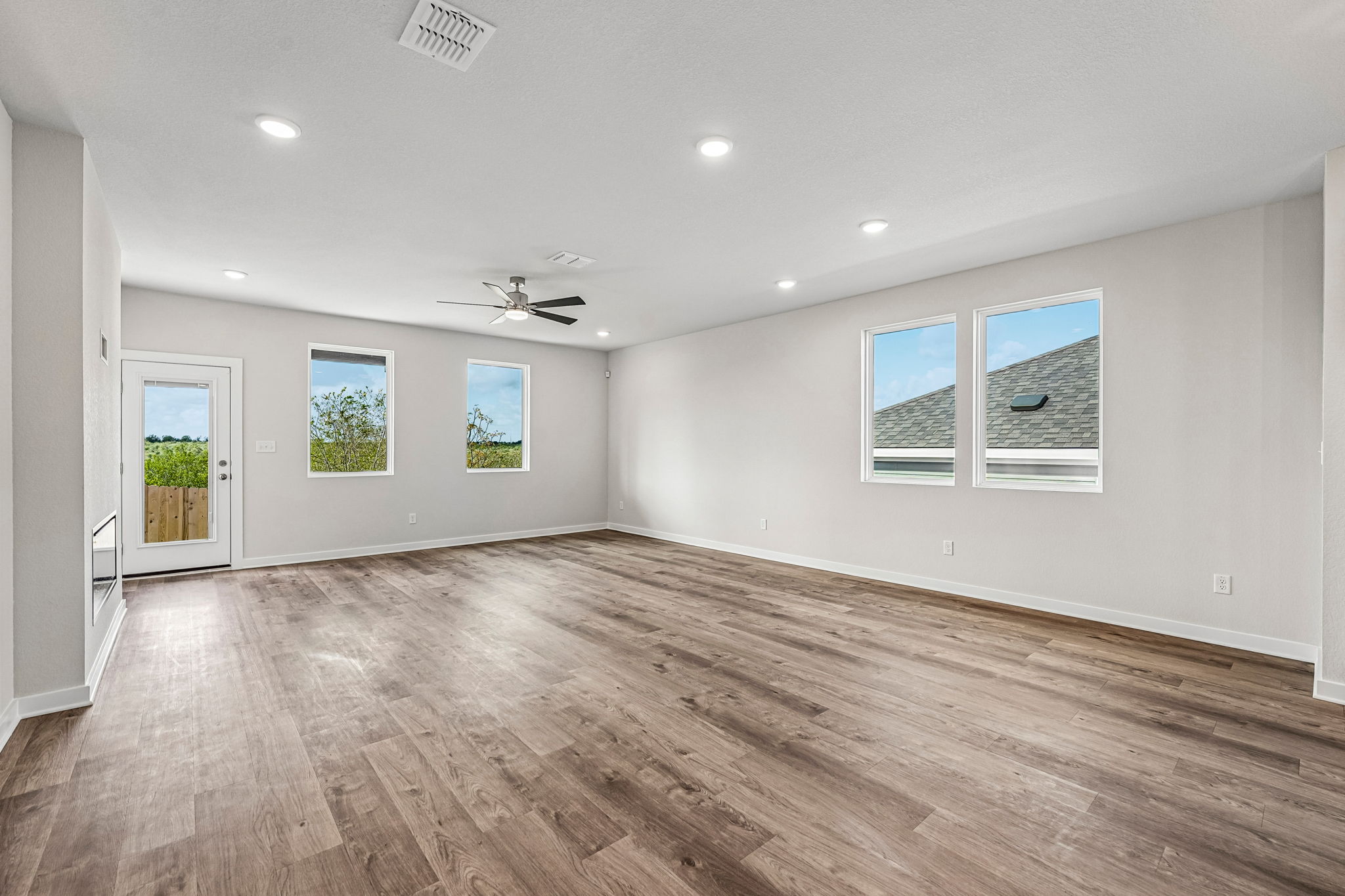 A room with a wood floor and a wood floor with a ceiling fan.