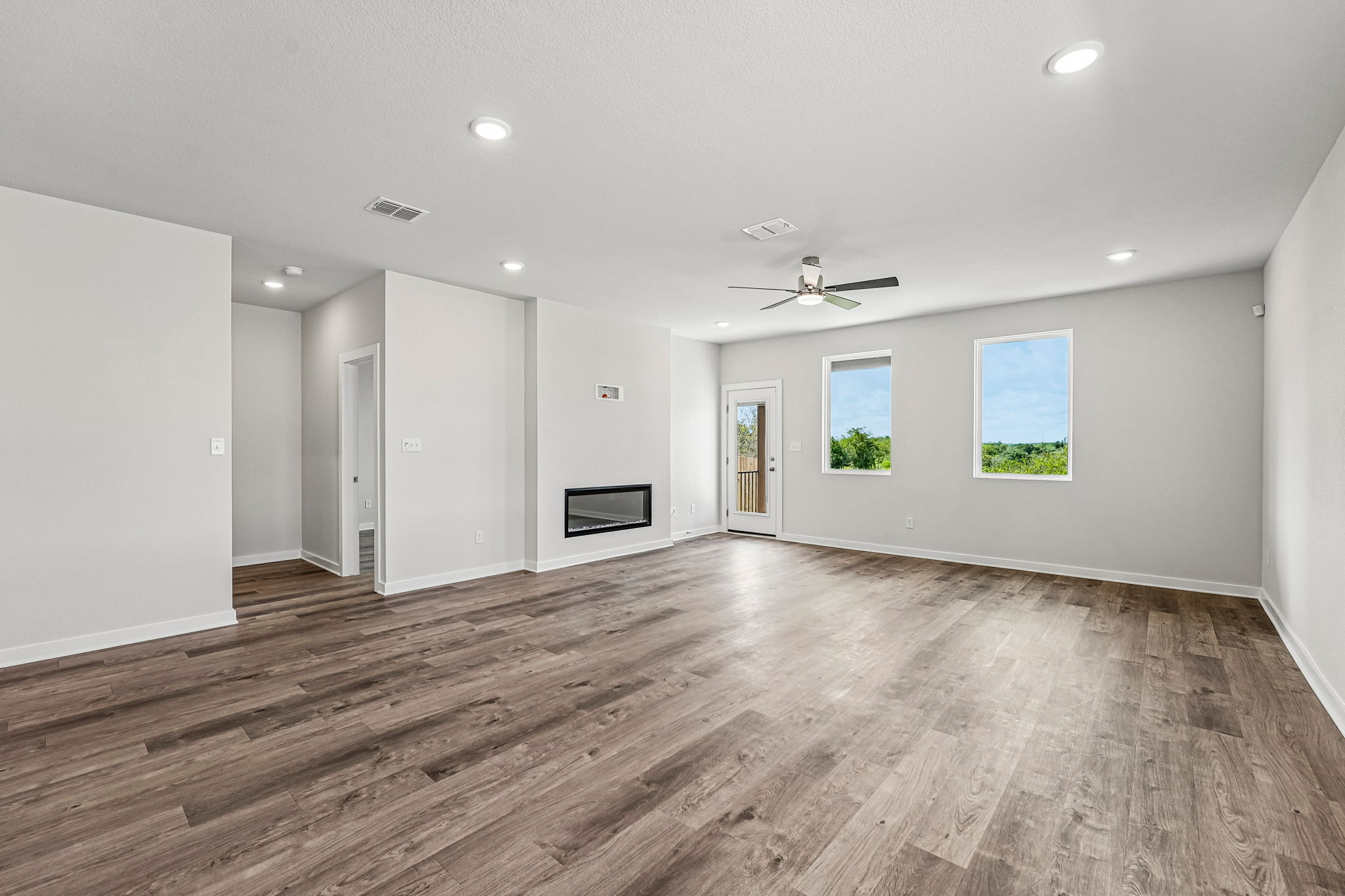 A large empty room with a wood floor and a wood floor.