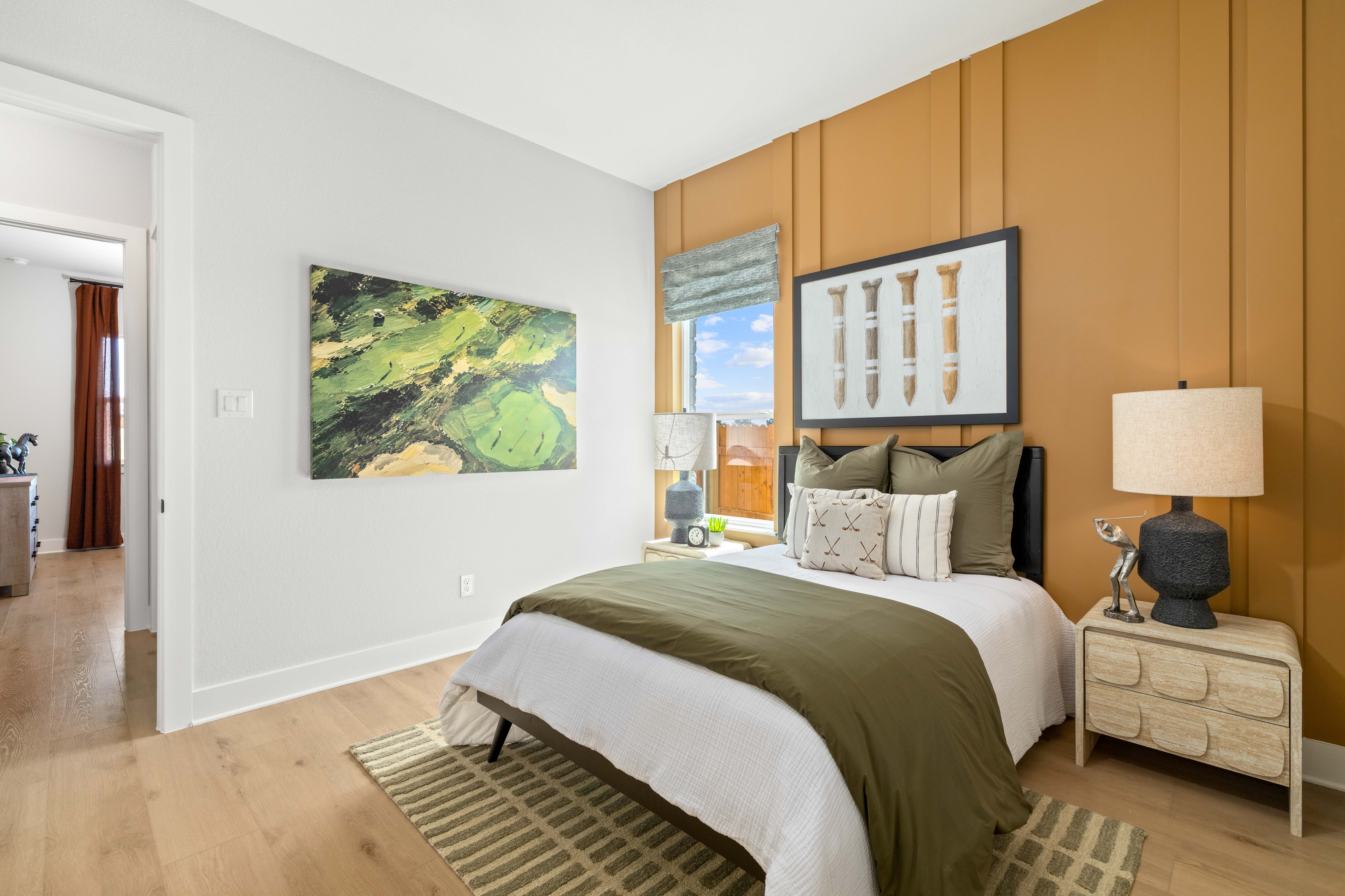 A bedroom with a large painting on the wall.
