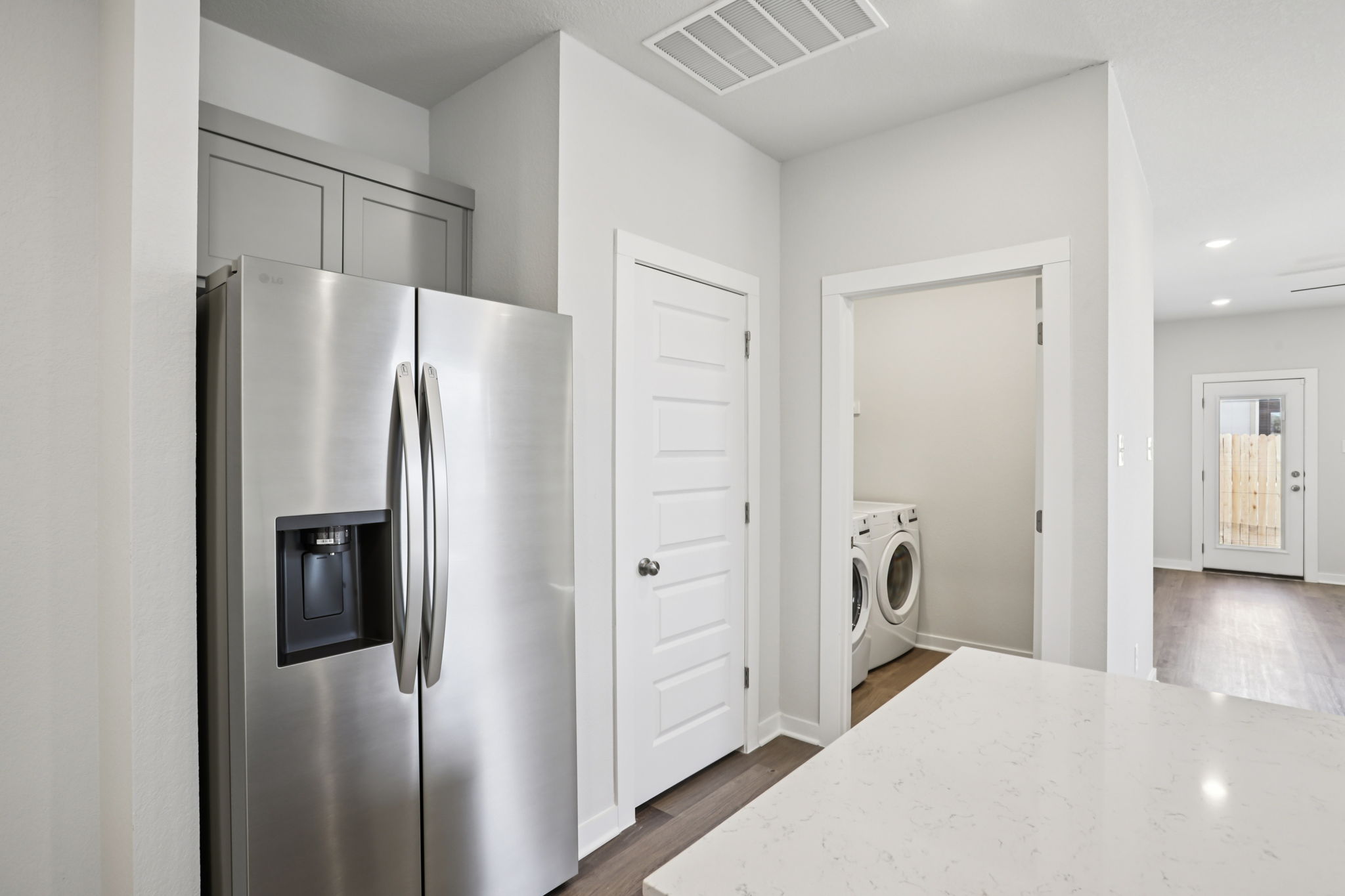 A kitchen with white cabinets.