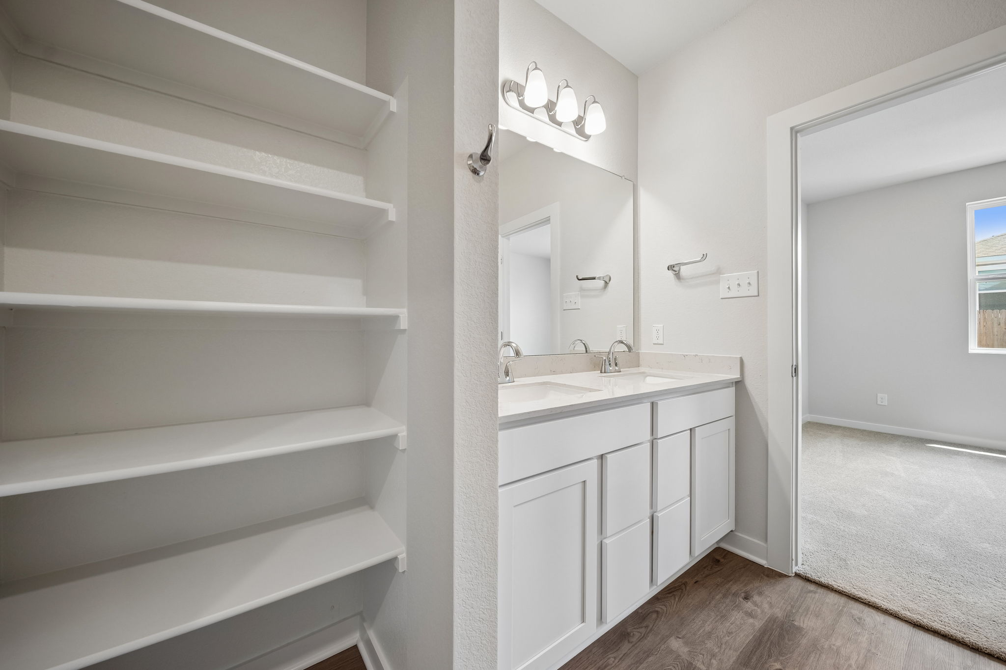 A bathroom with white cabinets.