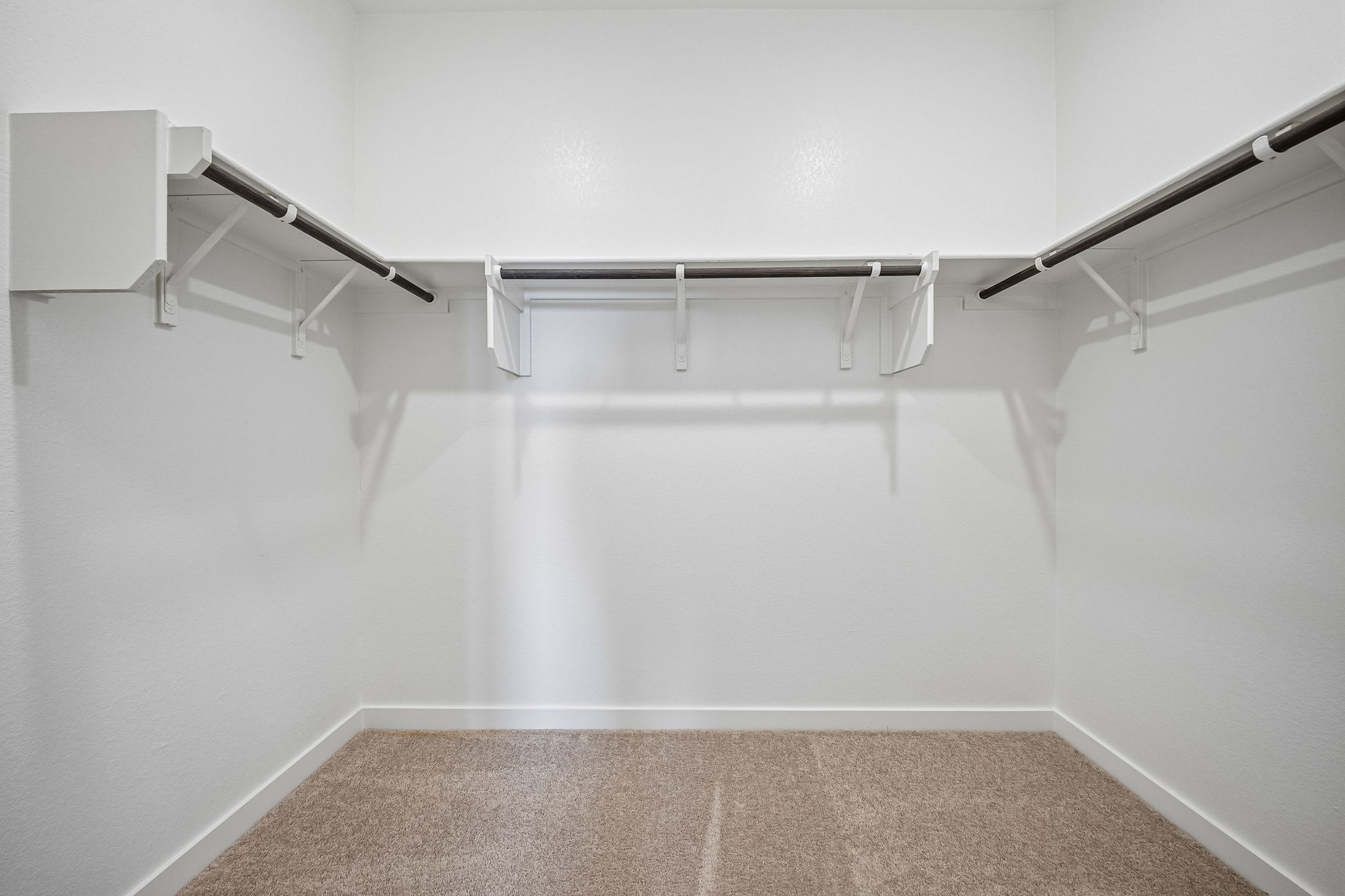 A white wall with a metal bar.