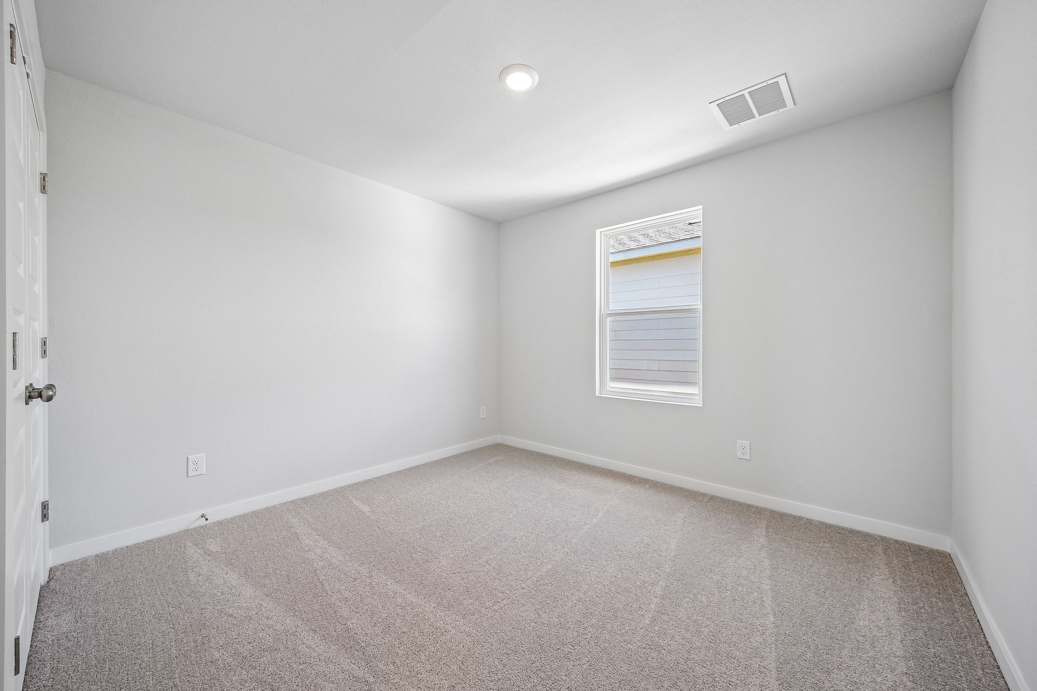 A room with a carpet and a door.