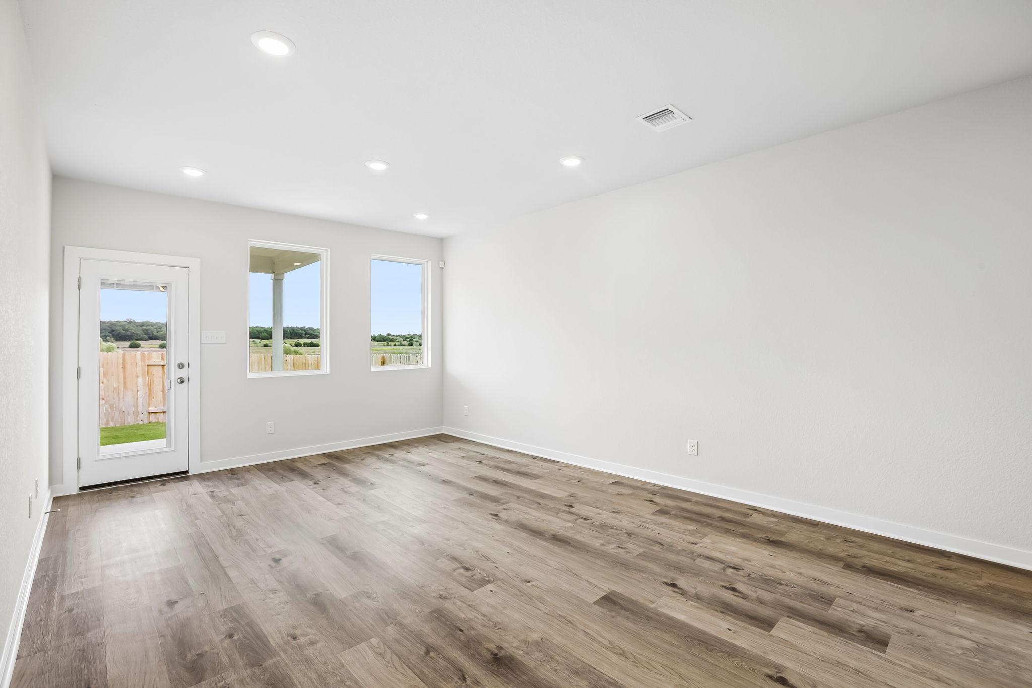 A room with windows and wood floors.