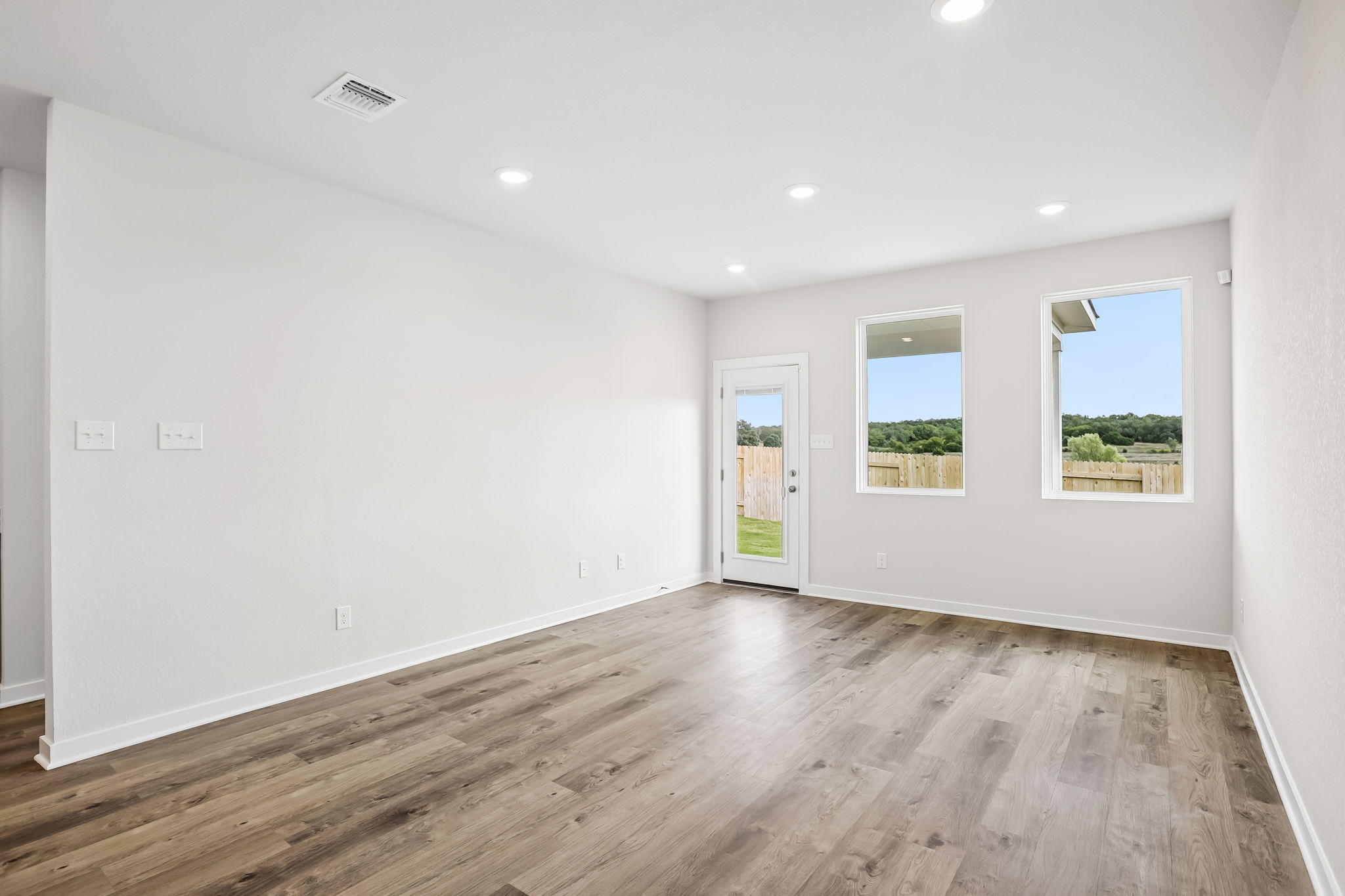 A room with a wood floor and windows.