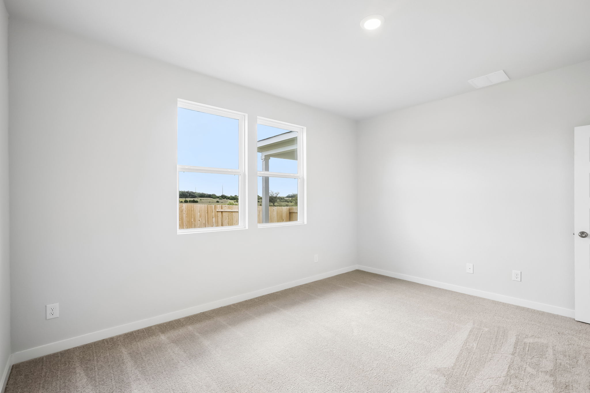 A room with a window and a carpet.