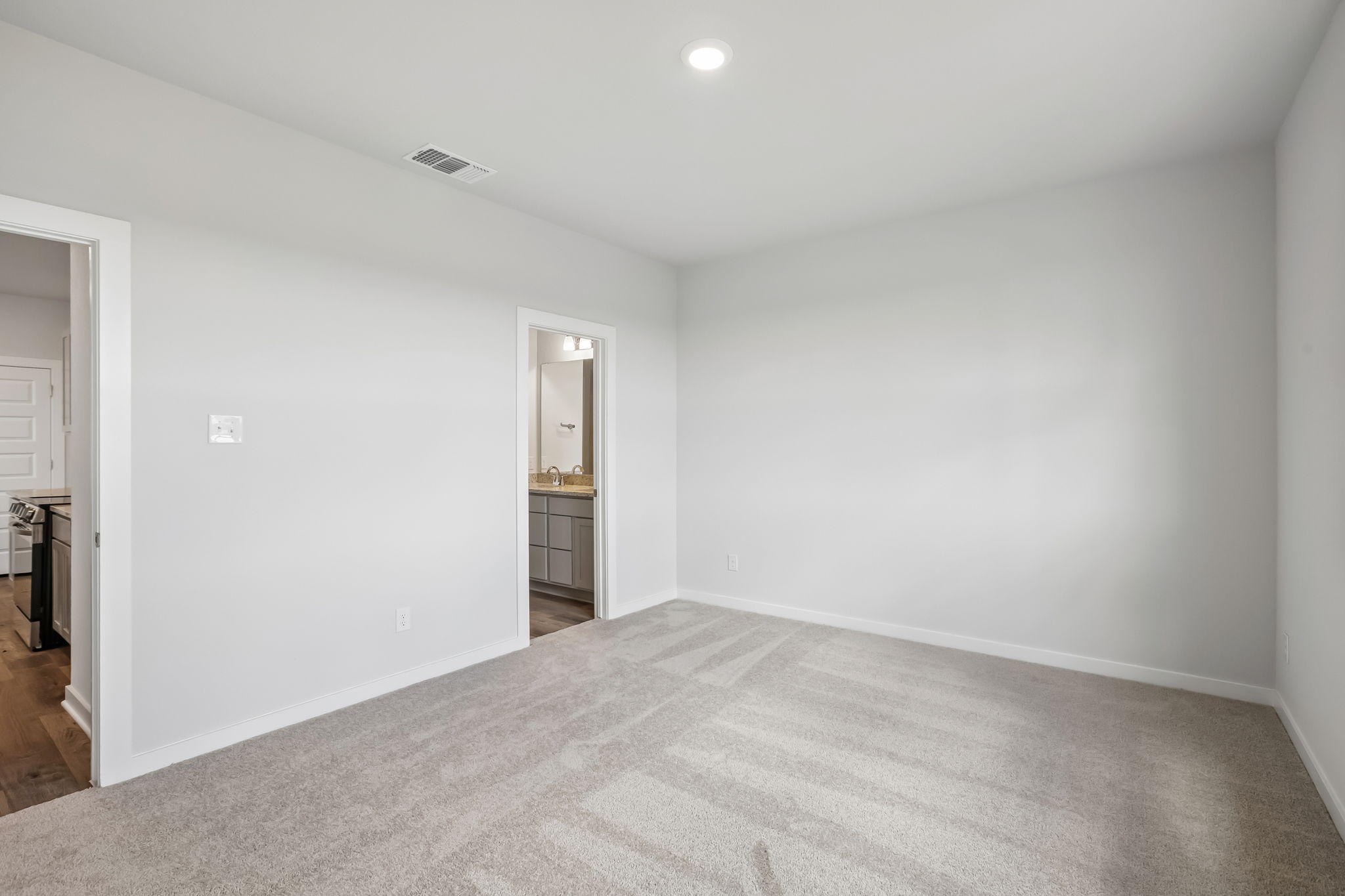 A room with a carpet and a door.