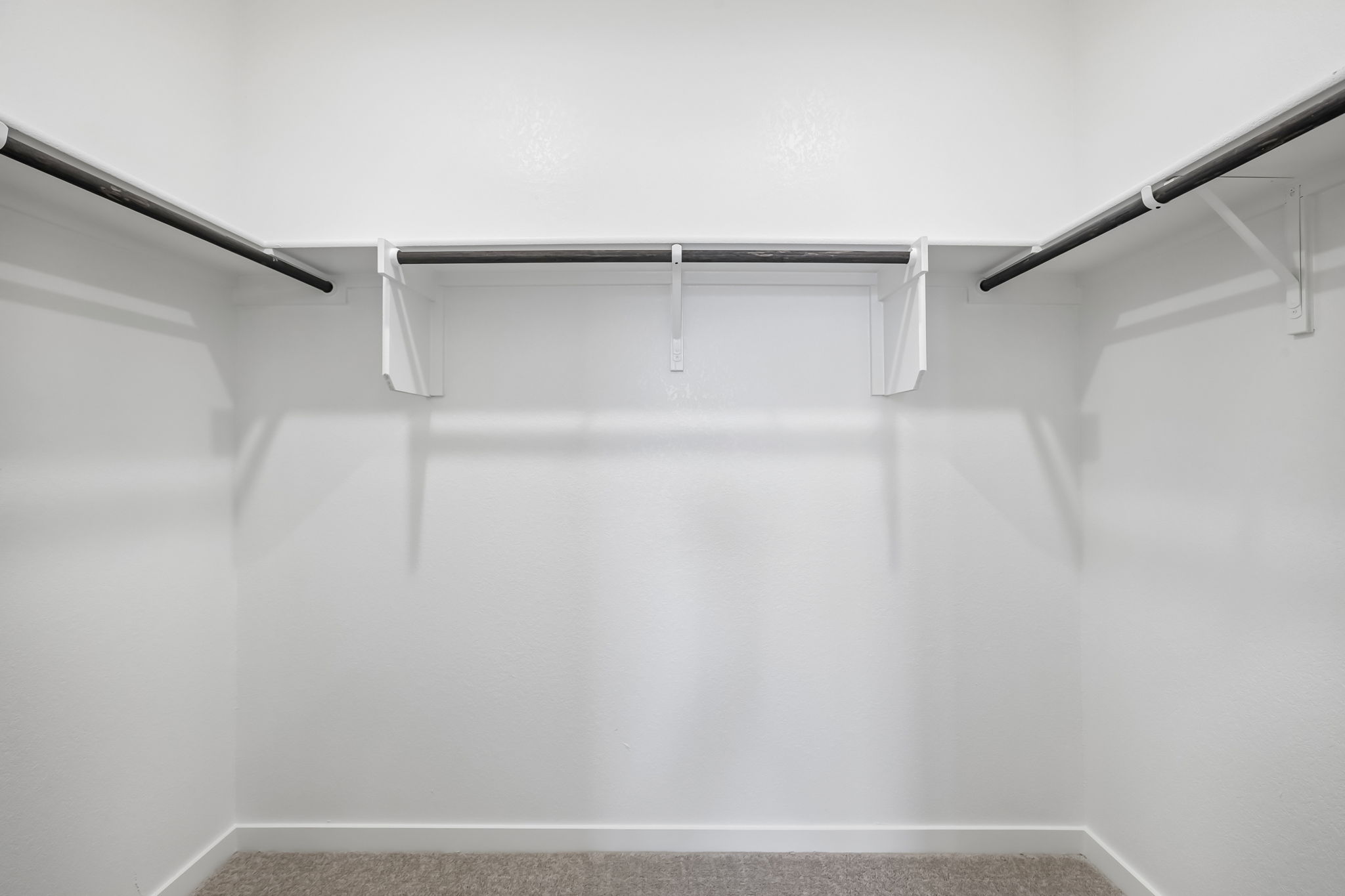 A white wall with a metal bar.