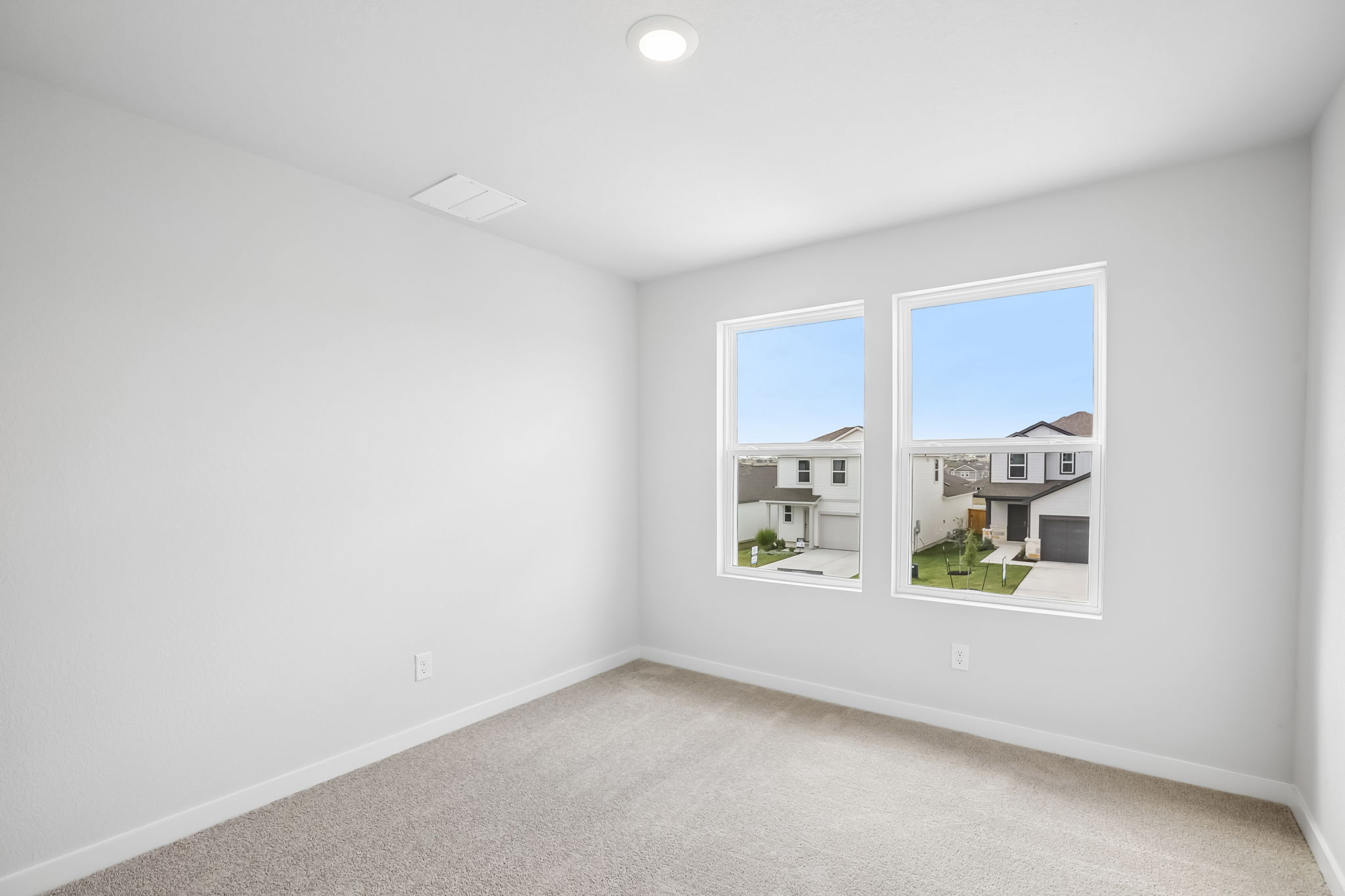 A room with a window and a white wall.