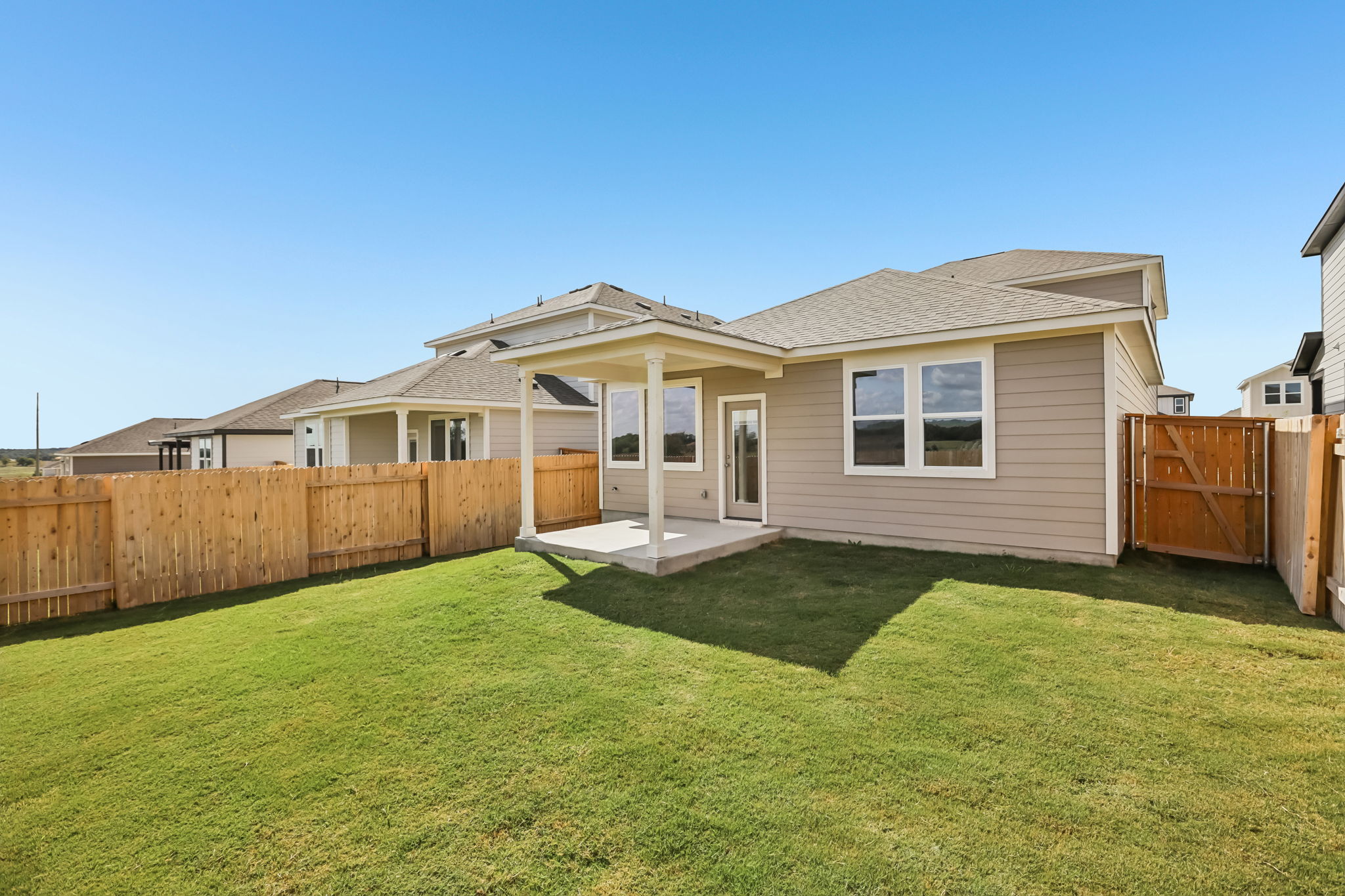 A house with a fence and a lawn.