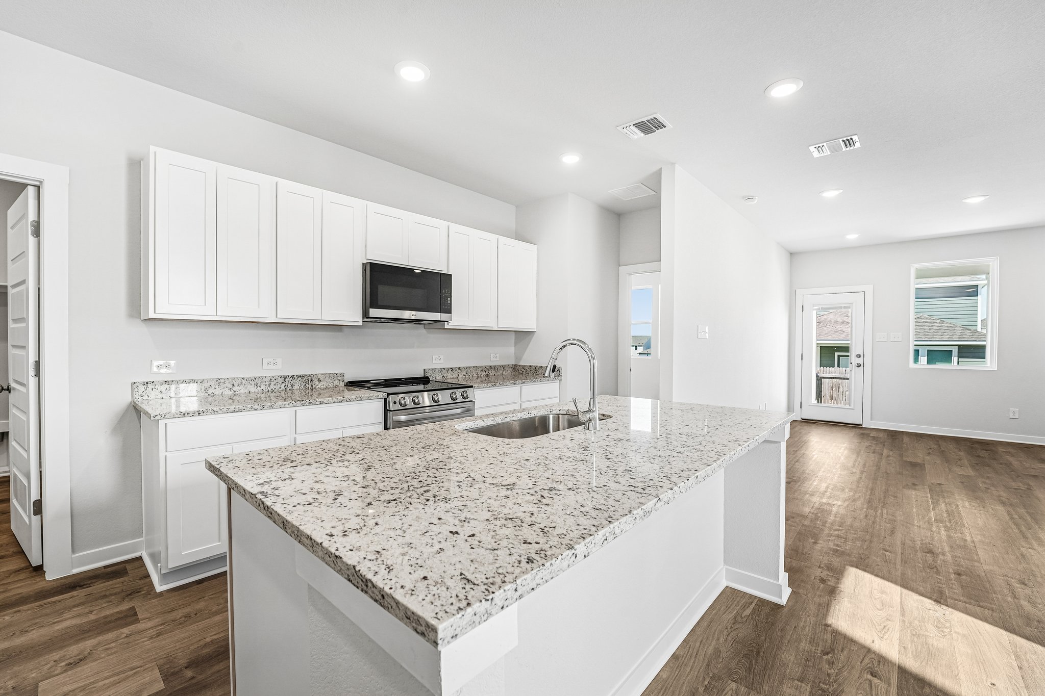A kitchen with white cabinets.