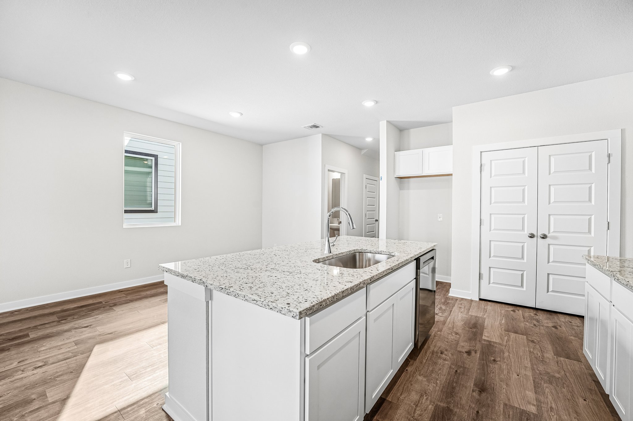 A kitchen with white cabinets.
